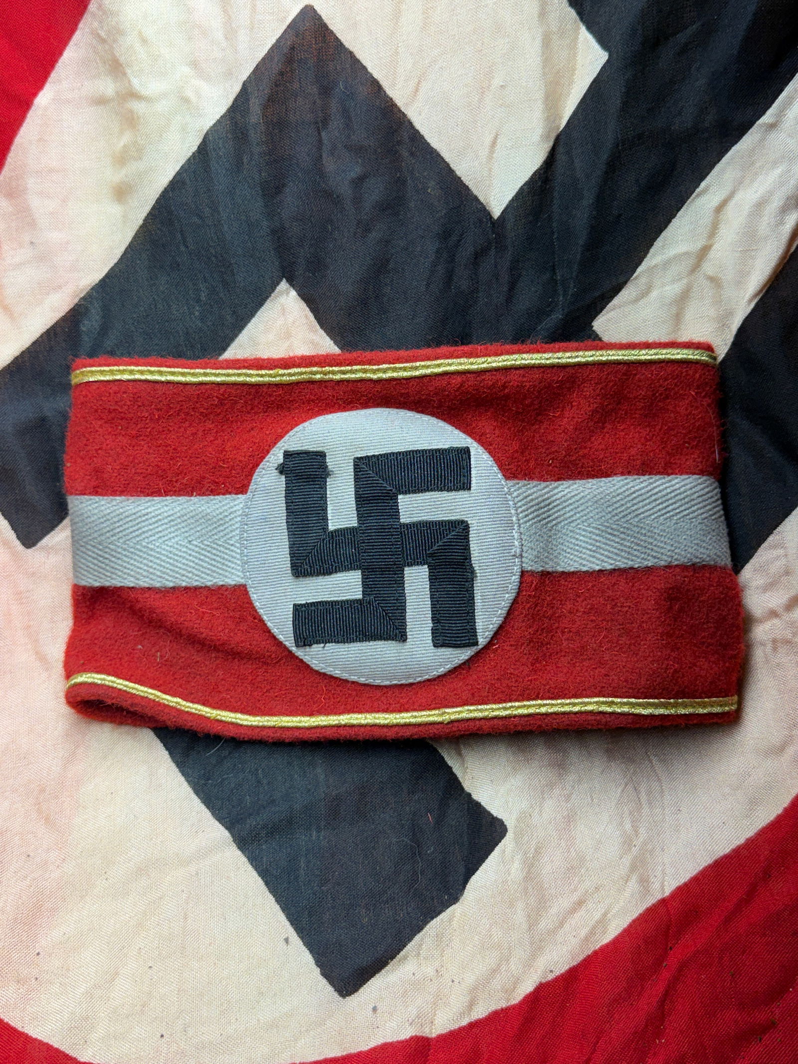 WW2 German Armband of Allegiance: Nazi Party Political Armband (Germany, 1937) With RZM Paper Tag: This red wool armband bears the black swastika within a white roundel, the central emblem of the National Socialist German Workers’ Party (NSDAP). Such armbands were worn by party members and offici