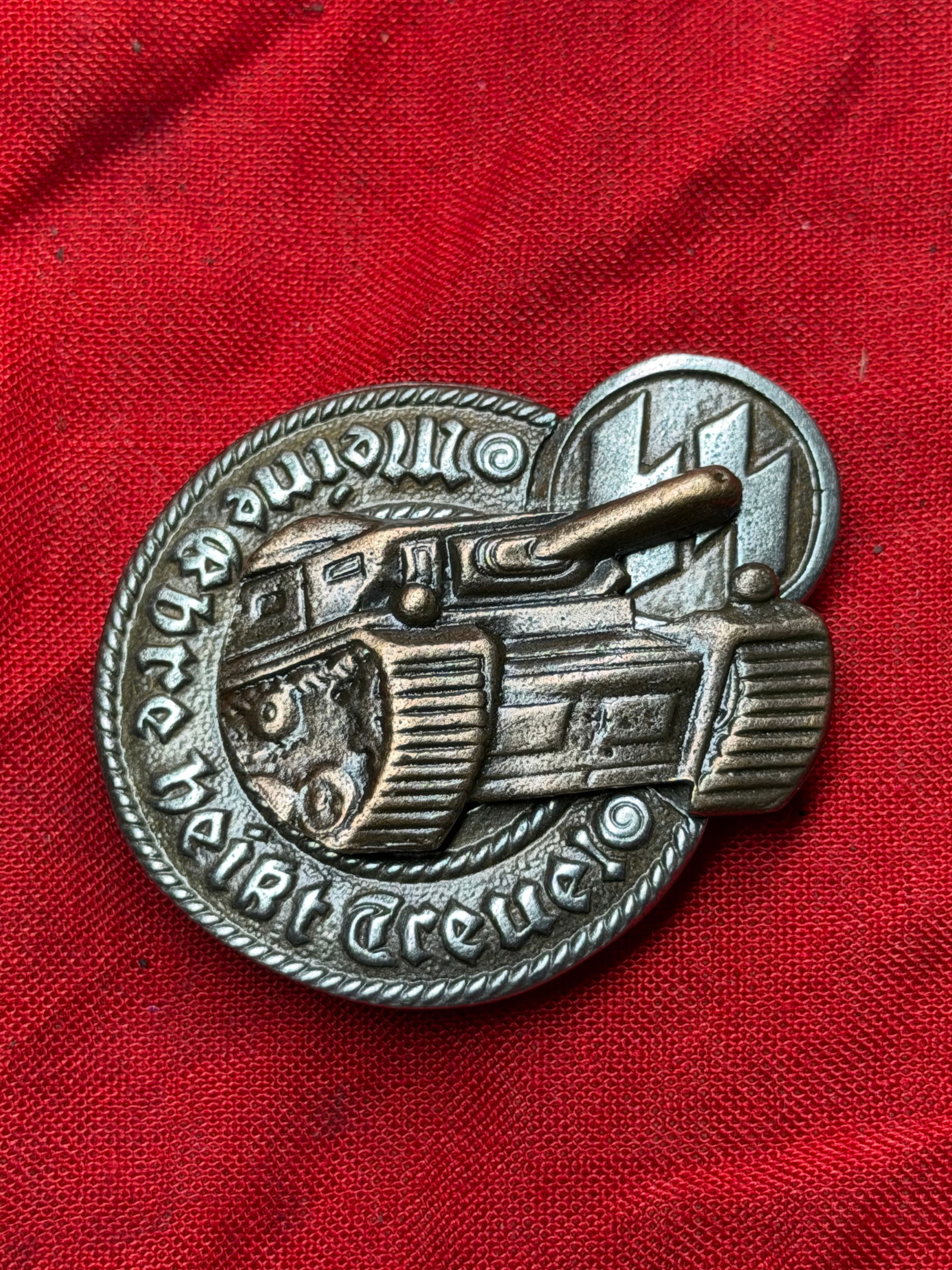 WW2 German Panzer Assault Badge (Panzerkampfabzeichen), Waffen-SS Variant: This metal badge is a German Panzer Assault Badge, awarded during the Second World War to armored troops for participation in frontline tank combat. The central relief depicts a German battle tank adv