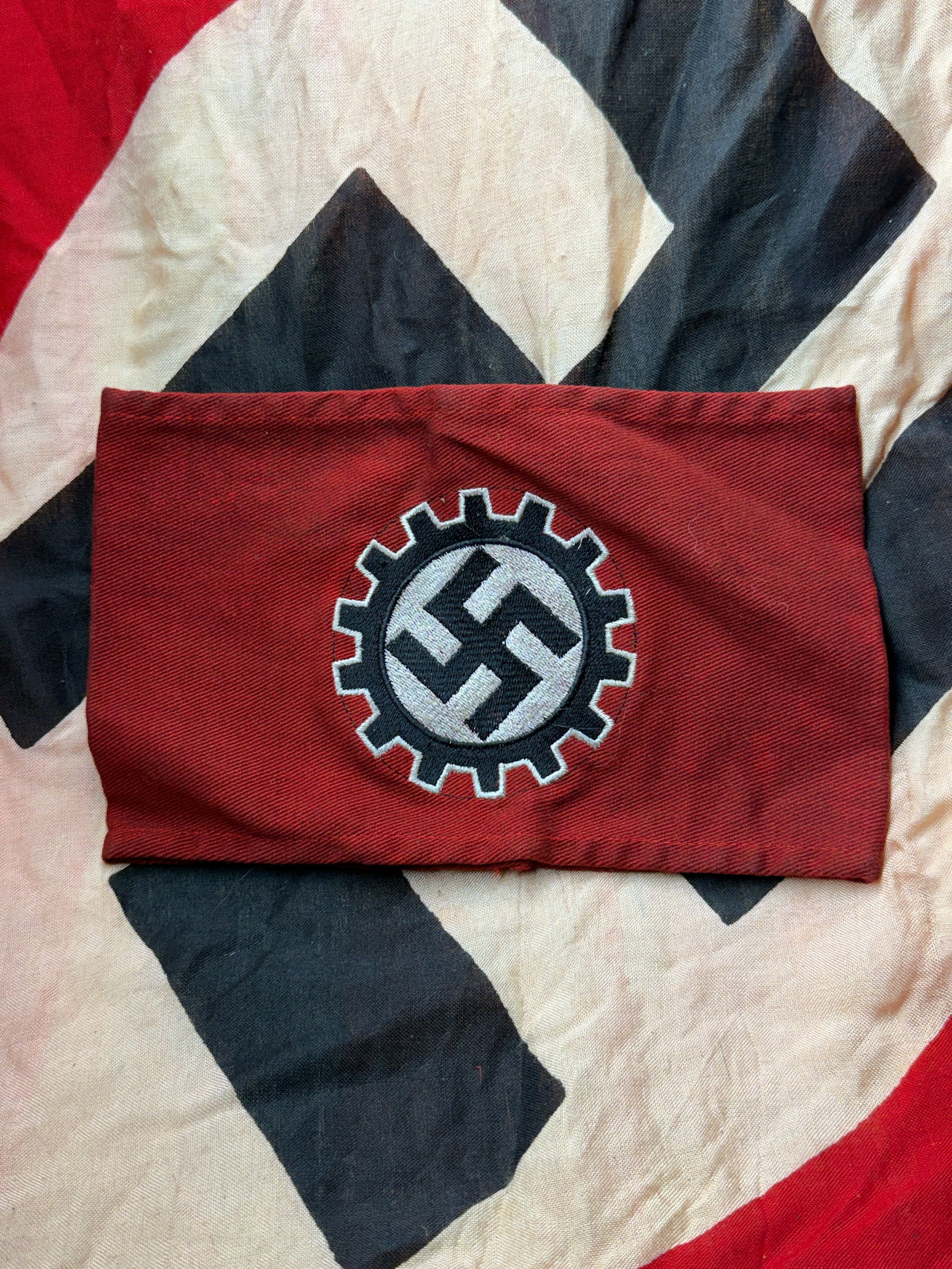 WW2 German Armband of the German Labour Front (Deutsche Arbeitsfront, DAF) With RZM Paper Tag: This armband belonged to the German Labour Front (Deutsche Arbeitsfront, DAF), the state-controlled organization that replaced independent trade unions in Nazi Germany after 1933. Constructed of red c