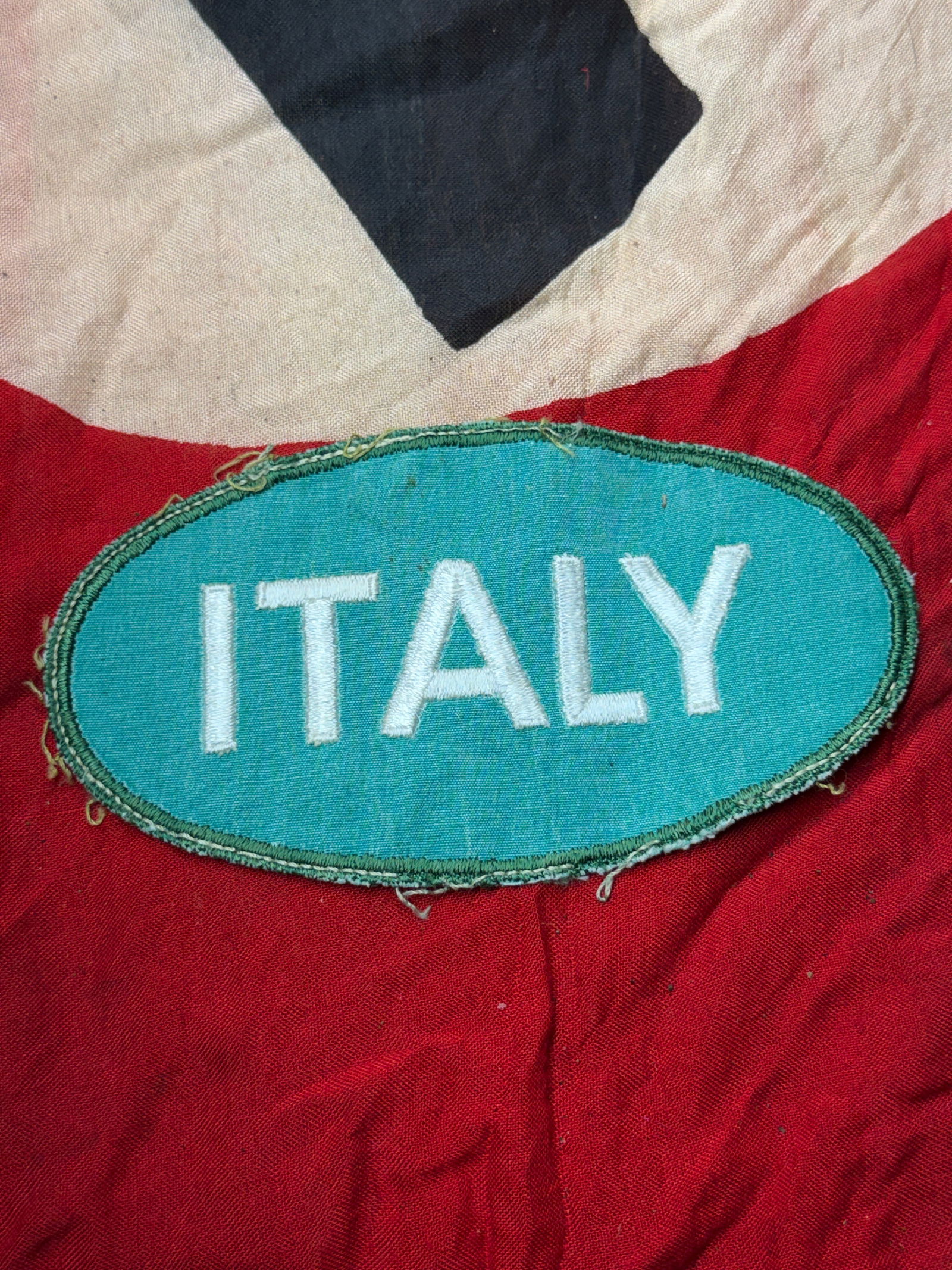 Italian Nationality Shield (“ITALY / ITALI??), Axis Forces, Second World War: This oval cloth nationality shield identifies Italian personnel serving alongside German forces during the Second World War. Produced in teal-green fabric with machine-embroidered white lettering, the