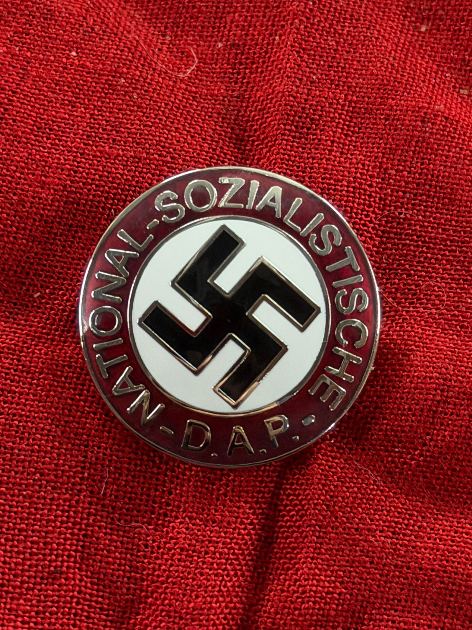 WW2 German NSDAP Party Membership Badge (Parteiabzeichen) By RZM M1/129: This circular enamel badge is the official National Socialist German Workers’ Party (NSDAP) membership badge, worn by party members throughout the Third Reich period. The design features a black swa