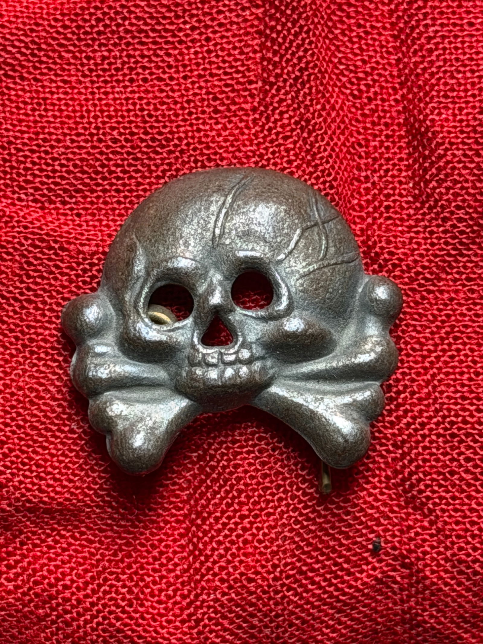 WW2 German SS Totenkopf (Death’s Head) Cap Insignia: This artifact is a German Totenkopf (Death’s Head) insignia, produced during the period of the Second World War (1939–1945). The skull-and-crossbones motif was worn primarily on headgear by units