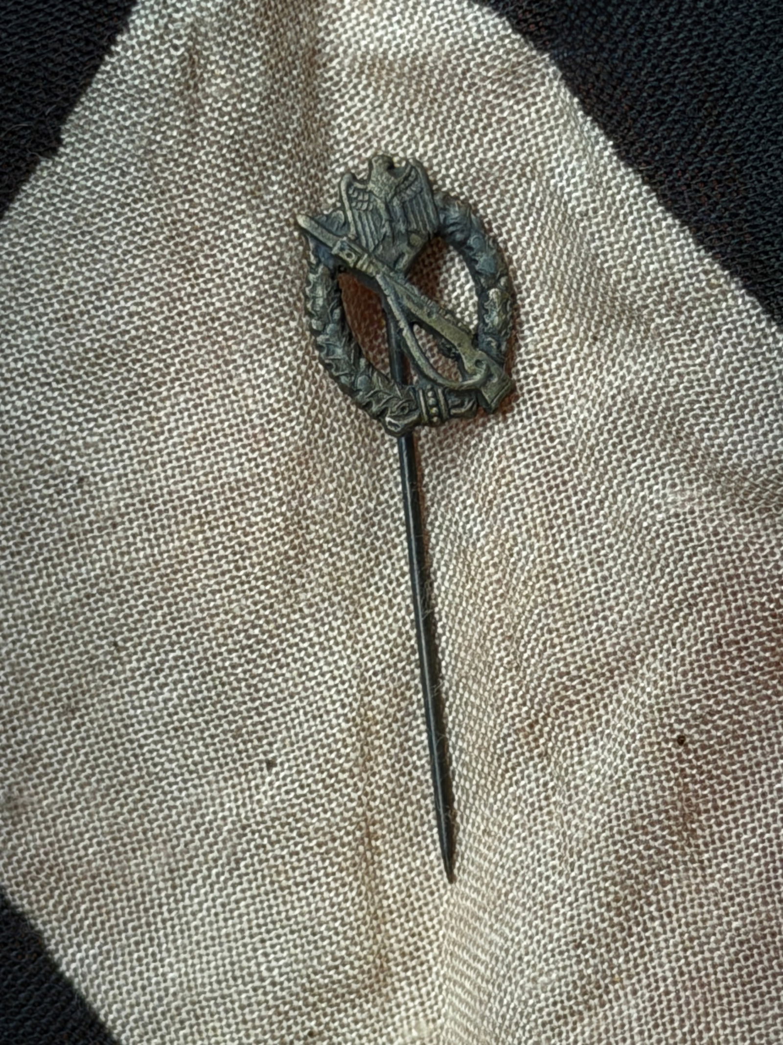 WW2 Miniature Infantry Assault Badge (Stickpin Form): This miniature stickpin represents the Infantry Assault Badge (Infanterie-Sturmabzeichen), a German military award instituted in 1939 and issued during the Second World War. The design features a Wehr