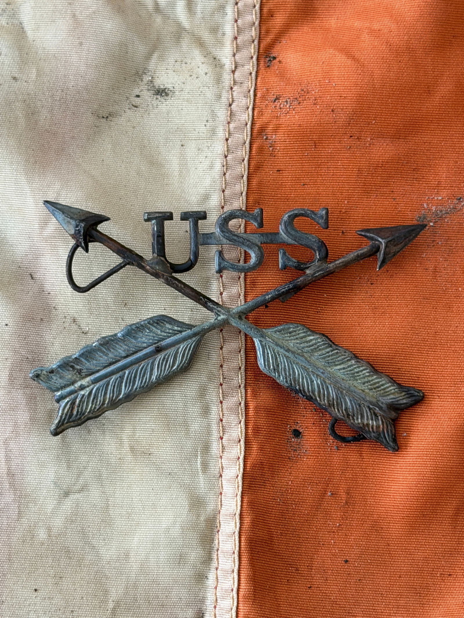 U.S. Scout Insignia, Indian Wars Period (Crossed Arrows with “USS??): This metal insignia consists of crossed arrows surmounted by the letters “USS,” identifying it as a badge worn by United States Scouts during the Indian Wars of the late 19th century. Cast in