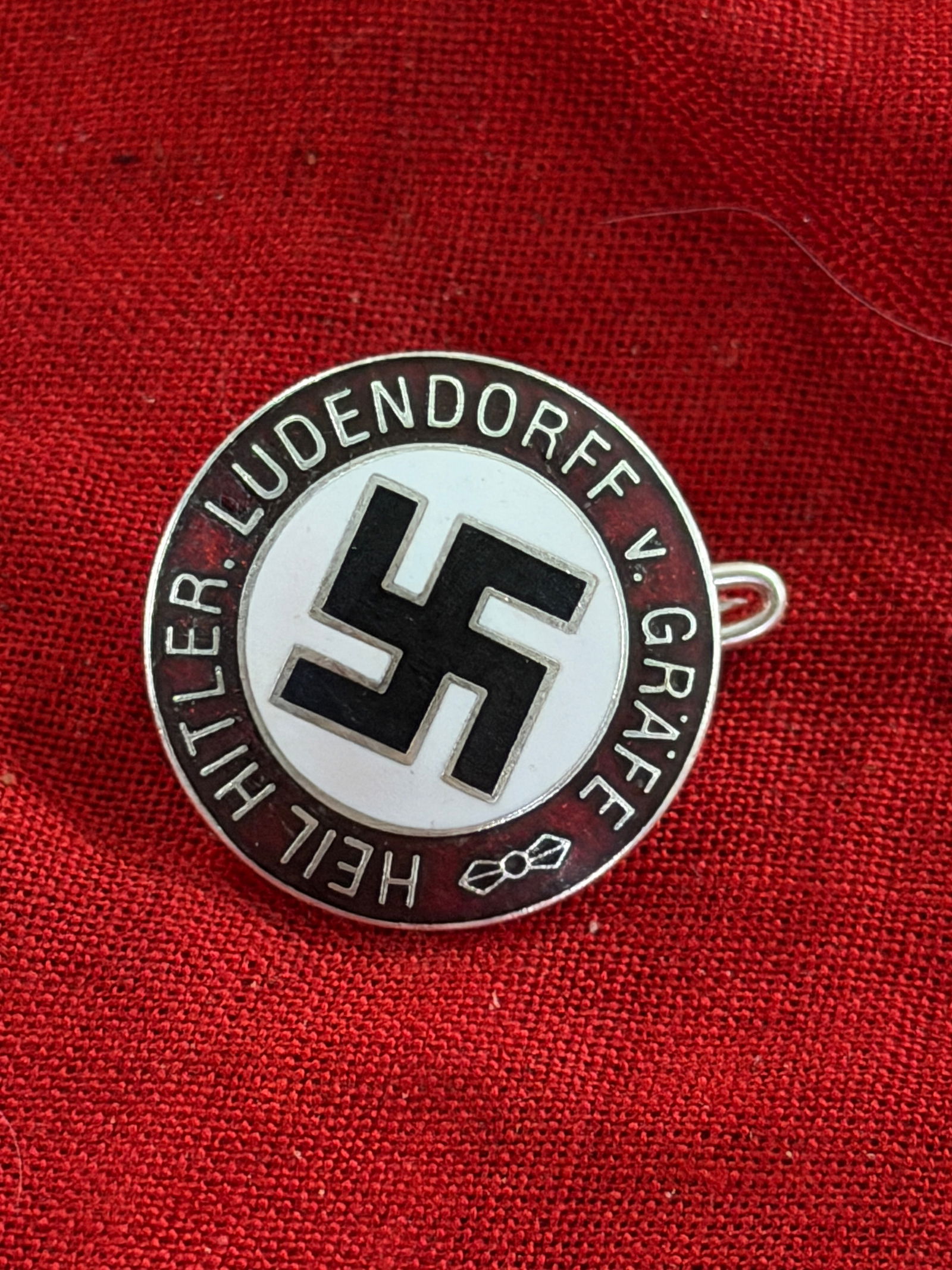 WW2 German Hitler Youth Commemorative Badge, Heil Hitler – Ludendorff v. Grafe By GES. GESCH.: This small enamelled pin badge bears the inscription “Heil Hitler – Ludendorff v. Grafe” encircling a central swastika. The reverse is marked “GES. GESCH.” (gesetzlich geschützt, ��
