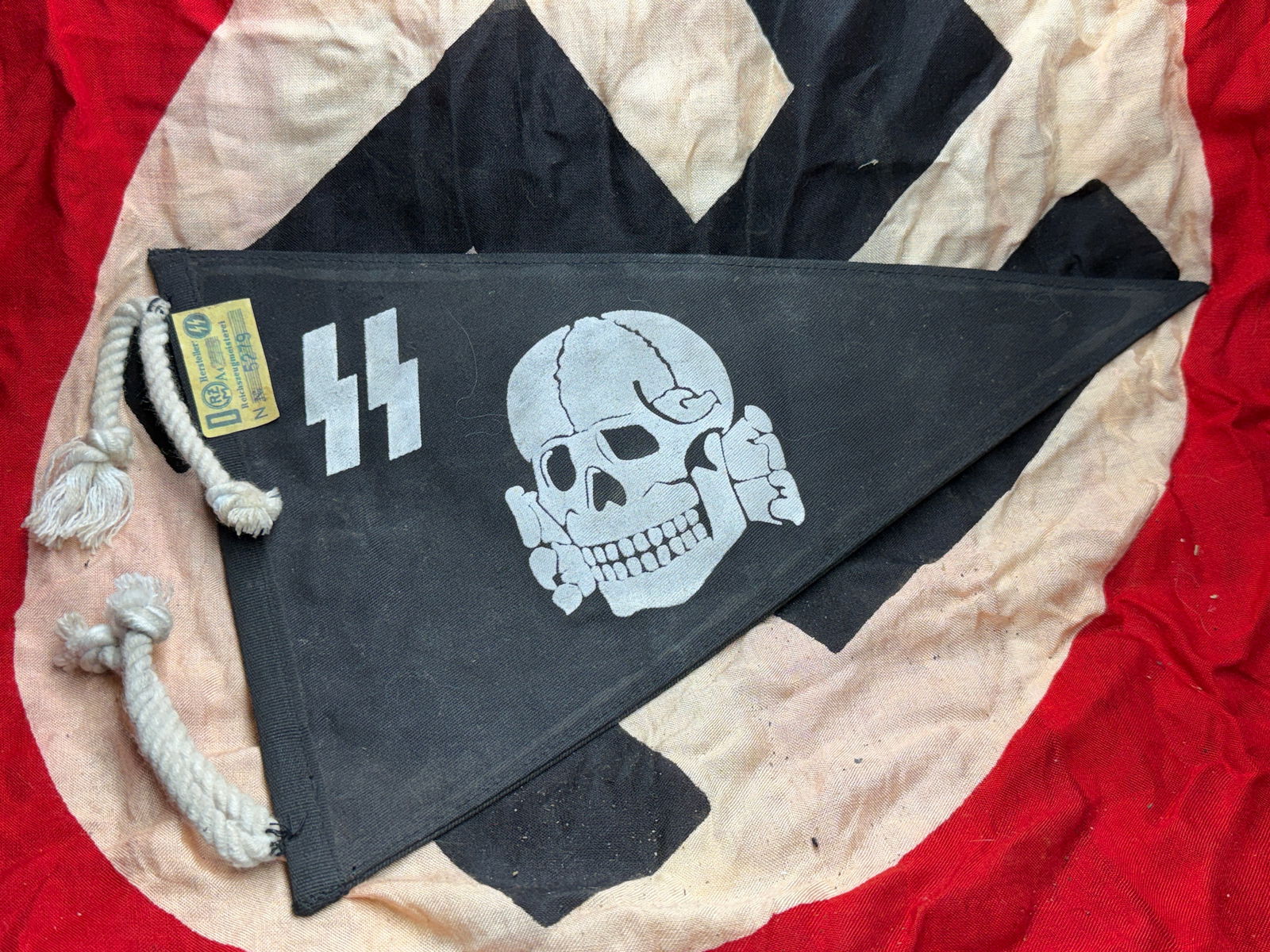 WW2 German SS Vehicle Pennant (Totenkopf), Nazi: This triangular black vehicle pennant is associated with units of the Schutzstaffel (SS) in Nazi Germany during the Second World War period (circa late 1930s–1945). The pennant displays the Totenkop