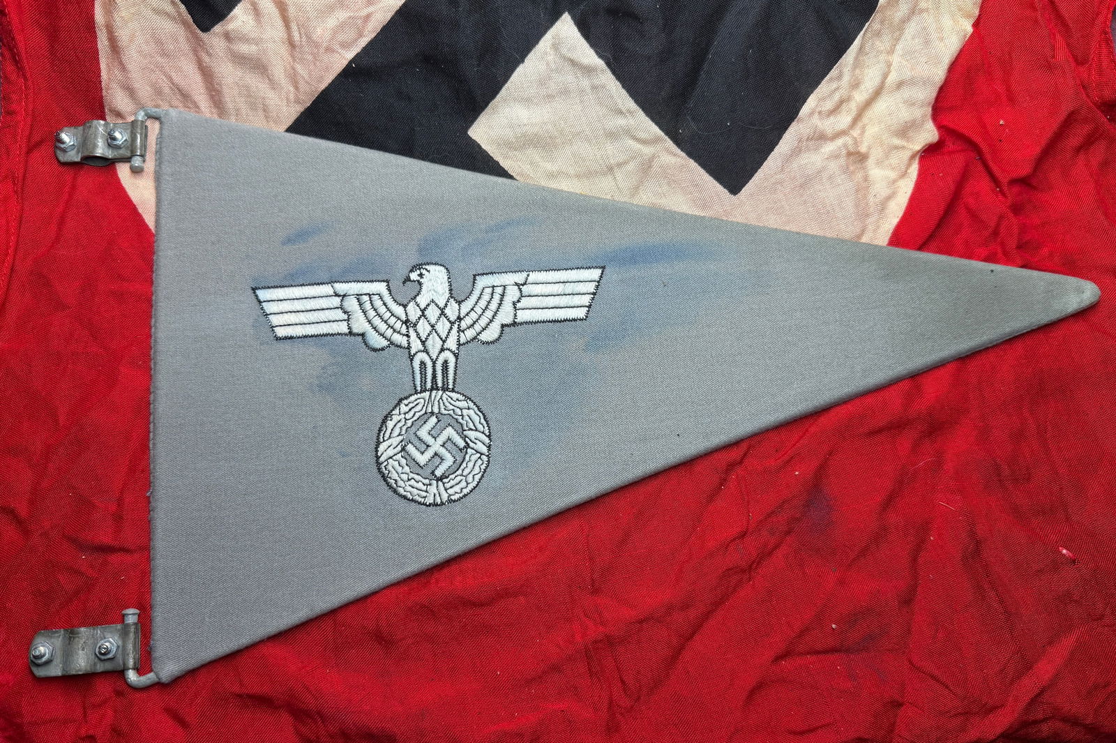 WW2 German Third Reich Vehicle Pennant with Eagle Emblem: This triangular cloth pennant features the embroidered German national eagle (Reichsadler) clutching a wreath enclosing a swastika, the official state emblem of Nazi Germany. The insignia in white thr