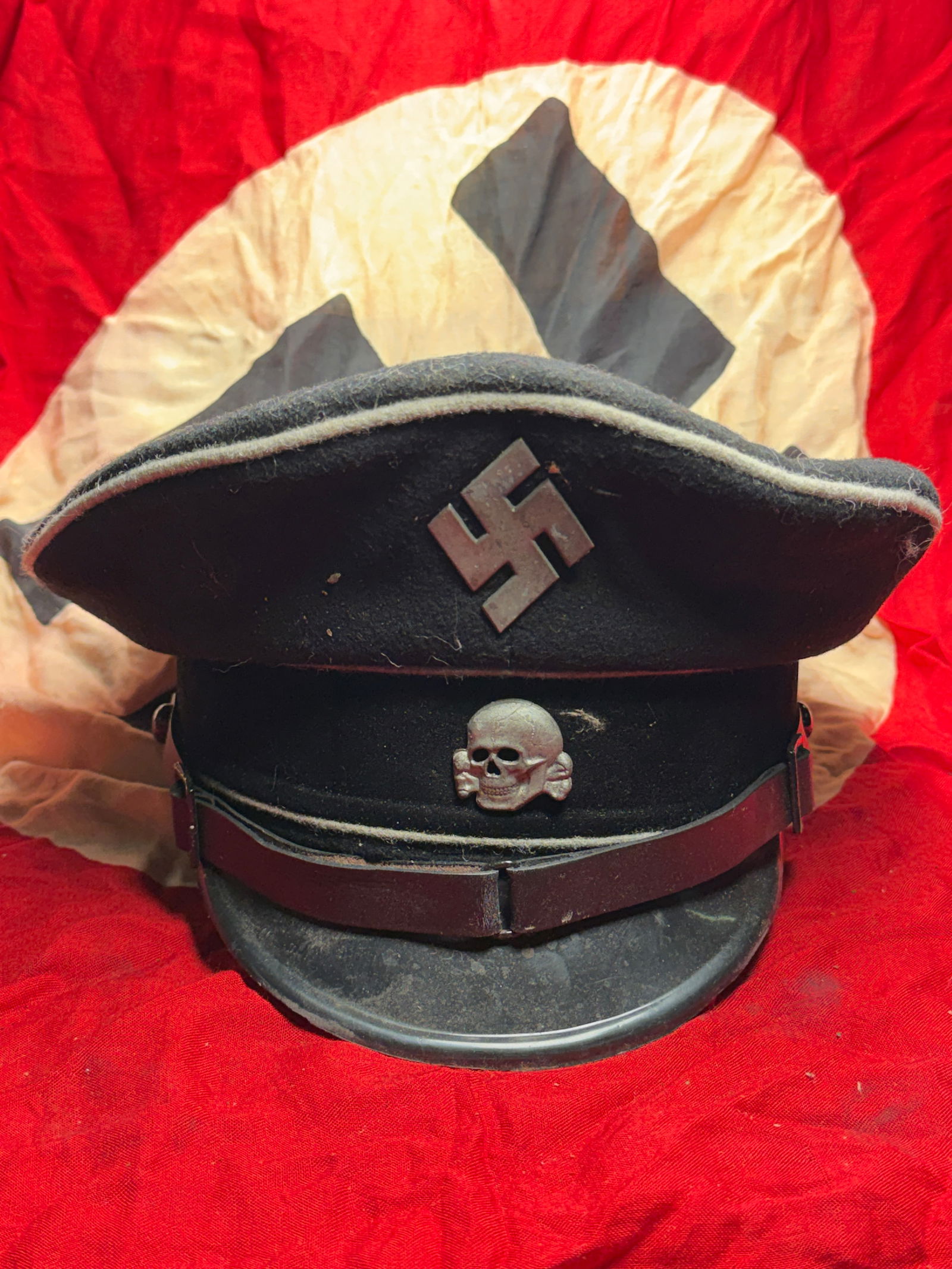 WW2 German SS Dienstmütze Death's Skull (Service Cap), Nazi: SS Dienstmütze (service cap) worn by members of the Schutzstaffel (SS) in Nazi Germany during the Second World War. The cap features insignia characteristic of SS uniform design: a metal skull (Toten