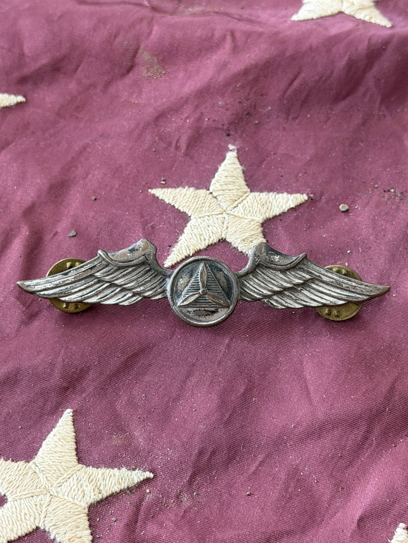 WW2 U.S. Army Air Forces Pilot Wings Insignia: This metal pilot’s wings insignia represents the United States Army Air Forces (USAAF), worn by qualified military aviators during the Second World War era. The design features outstretched wings fl