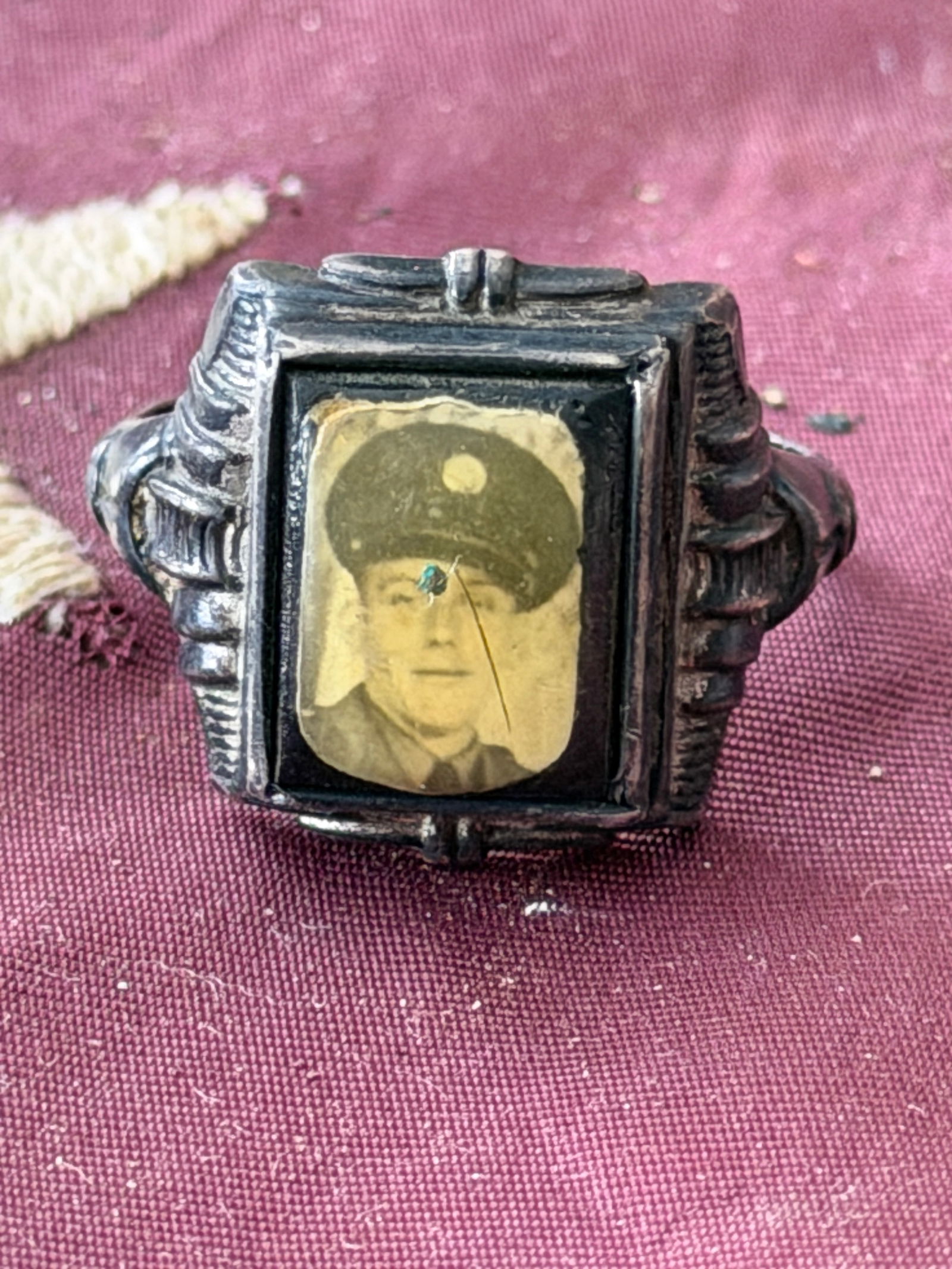 World War II Sterling Silver Soldier Portrait Ring: This World War II–era sterling silver ring contains a miniature photographic portrait of a uniformed serviceman, preserved beneath a protective glass bezel. Rings of this type were popular during th