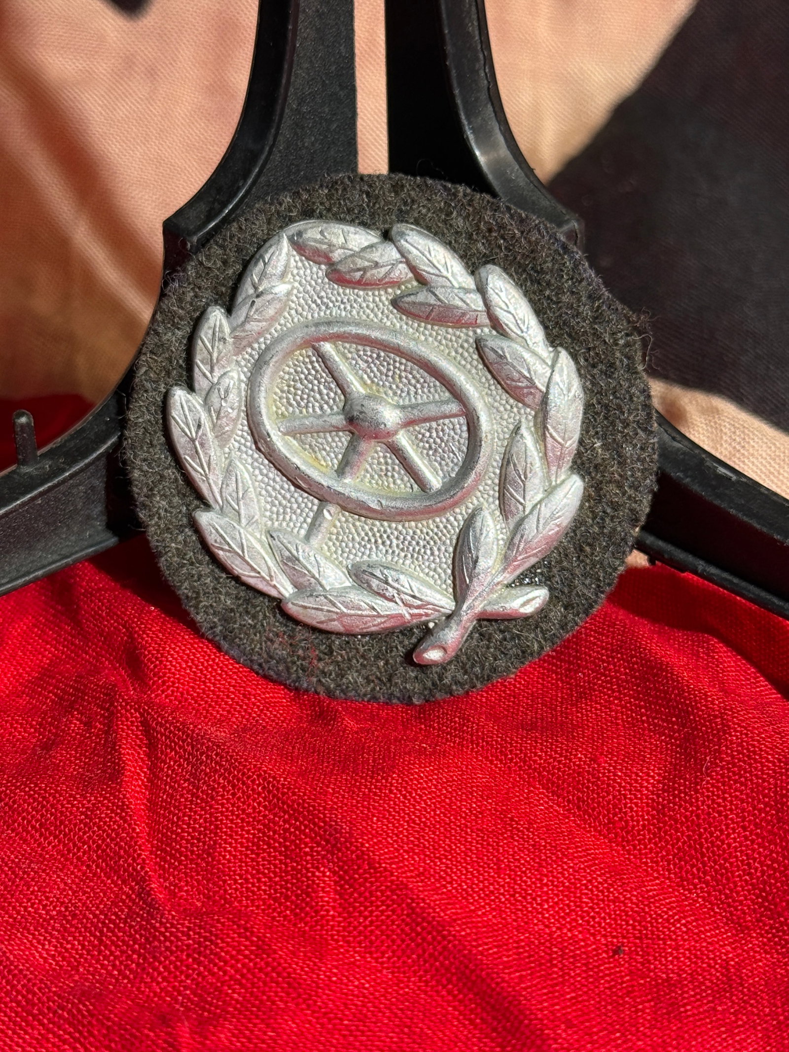 WW2 German Motor Transport Driver Proficiency Badge - Maker Marked (Kraftfahrbewährungsabzeichen),: Maker Marked German motor transport driver proficiency badge featuring a steering wheel within an oak-leaf wreath, mounted on a dark cloth backing. This style of badge was awarded to qualified drivers