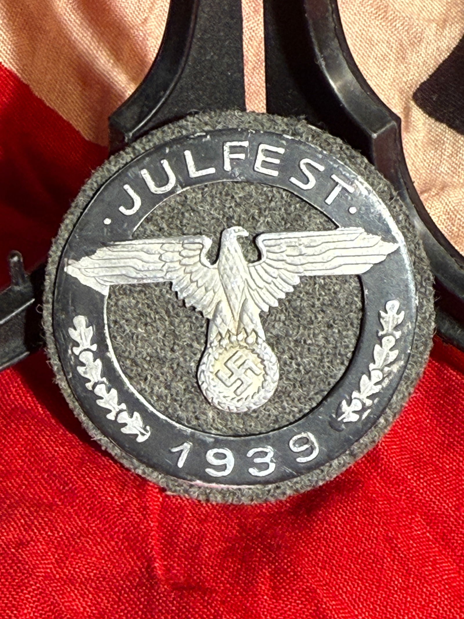 WW2 German Winter Relief Fund “Julfest?? Badge, 1939 (Wittmann, München): German Julfest 1939 Winter Relief (WHW) badge featuring an eagle with wreath and dated “1939,” mounted on a dark cloth backing. Reverse marked “Wittmann München,” a known period manuf