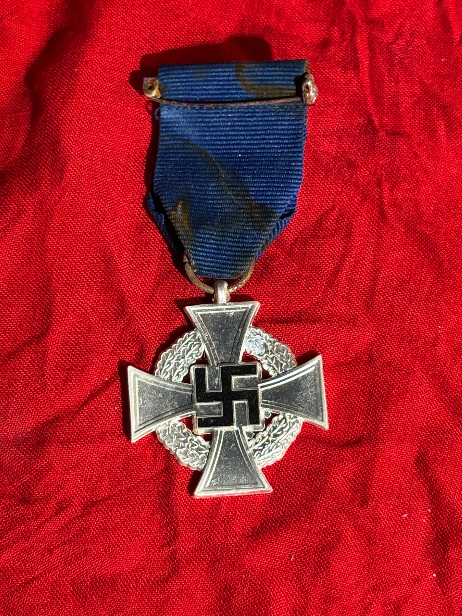 WW2 German 25-Year Faithful Service Medal (Treudienst-Ehrenzeichen für 25 Jahre), Nazi Germany, c.: Silver Faithful Service Medal awarded for 25 years of civil service in Nazi Germany. The decoration features a silver cross pattée with a black swastika at the center, set over a laurel wreath, suspe