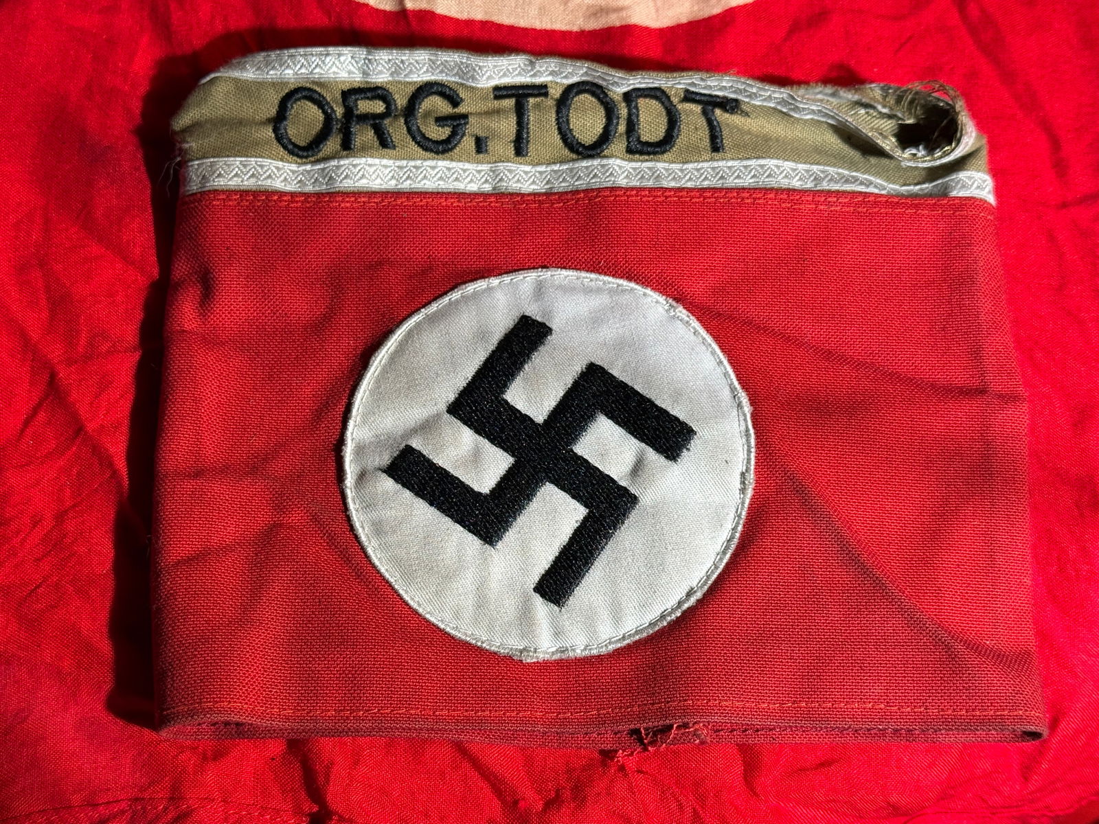 WW2 German Organization Todt (Org. Todt) Armband, Nazi Germany With RZM Paper Tag: Red cloth Organization Todt (Org. Todt) armband featuring a black swastika within a white roundel and an embroidered “ORG. TODT” designation band. Organization Todt was a major Nazi civil and