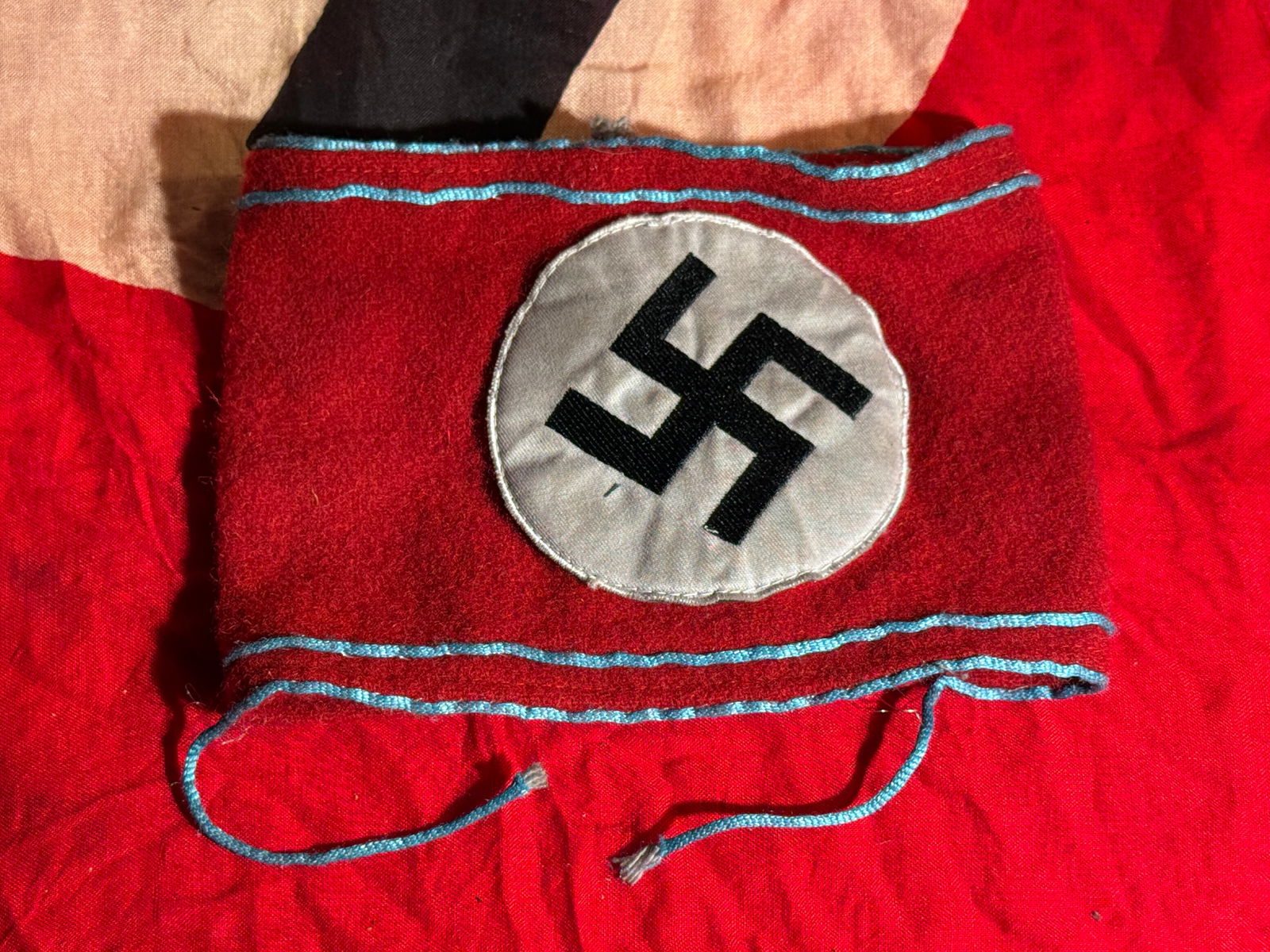 WW2 German NSDAP Political Leader Armband (Ortsgruppe Level), Third Reich,: Red wool Nazi Party (NSDAP) political leader armband featuring a black swastika within a white roundel, bordered by light blue piping bands that indicated a local-level party official (Ortsgruppe lead