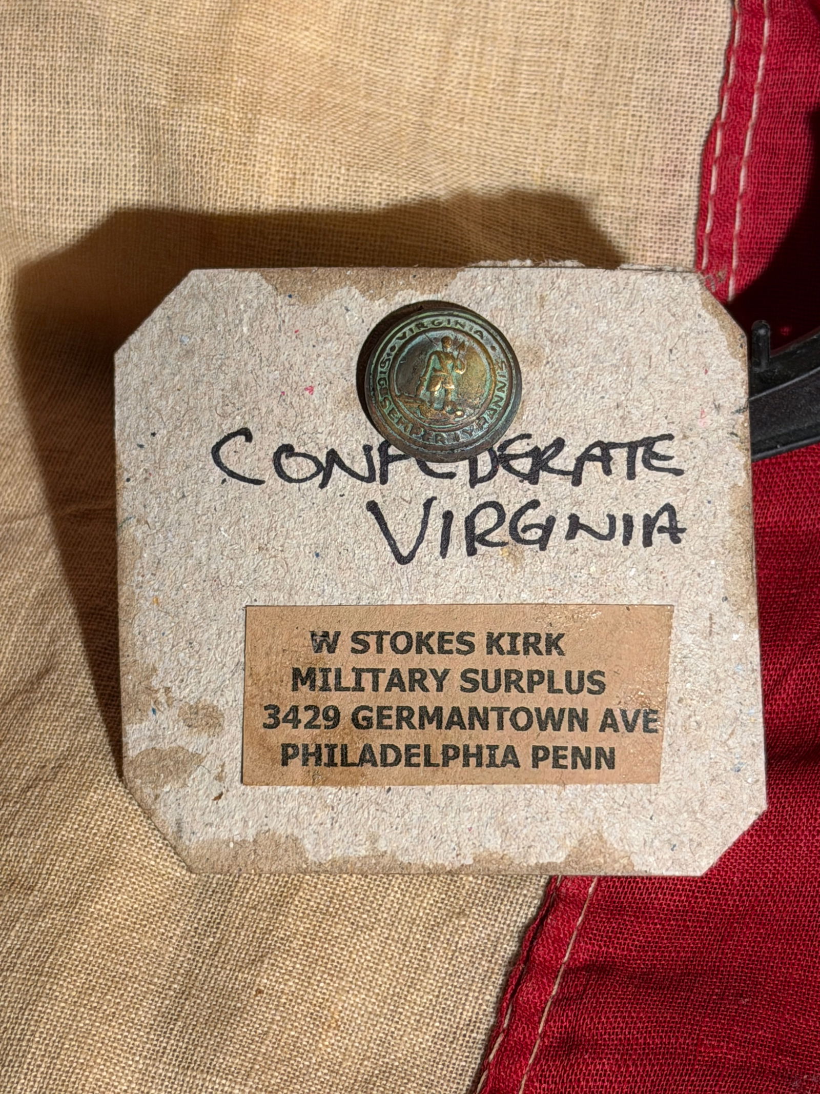 Confederate Virginia State Seal Uniform Button, American Civil War Era (c. 1861–1865): This small brass uniform button bears the seal of the Commonwealth of Virginia, depicting the classical figure of Virtus standing over a defeated tyrant, surrounded by the Latin motto “Sic Semper Ty