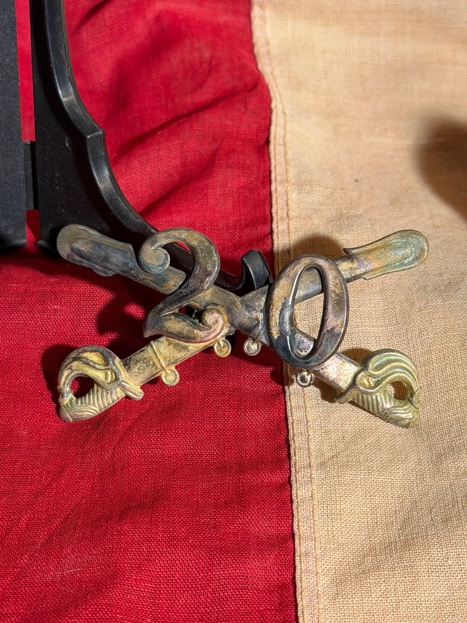Civil War Crossed Cavalry Sabers Insignia with Bugle Horn Badge: This brass military insignia features crossed cavalry sabers surmounted by a bugle horn, symbolic elements associated with mounted troops and cavalry communications. The curved sabers with ornate hilt