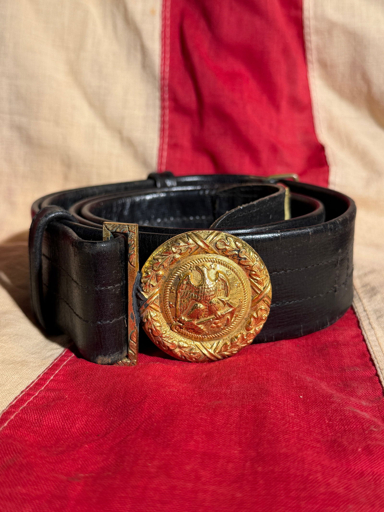 Union Army Eagle Belt Plate and Waist Belt, American Civil War Era: This waist belt with circular eagle belt plate is associated with the United States Army during the American Civil War period. The gilt brass buckle displays a spread-winged federal eagle clutching ar