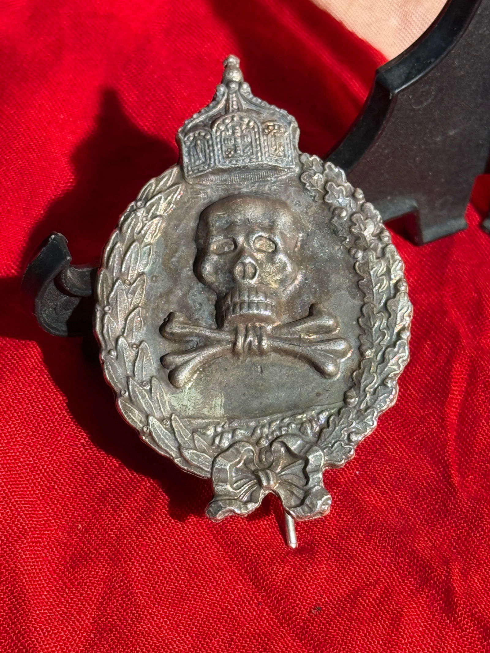 Imperial German Wound Badge in Silver (Verwundetenabzeichen), World War I Era: Wound badge associated with the German Empire during the First World War (1914–1918). The badge features a central Totenkopf (skull and crossed bones) motif beneath the Imperial crown, encircled by