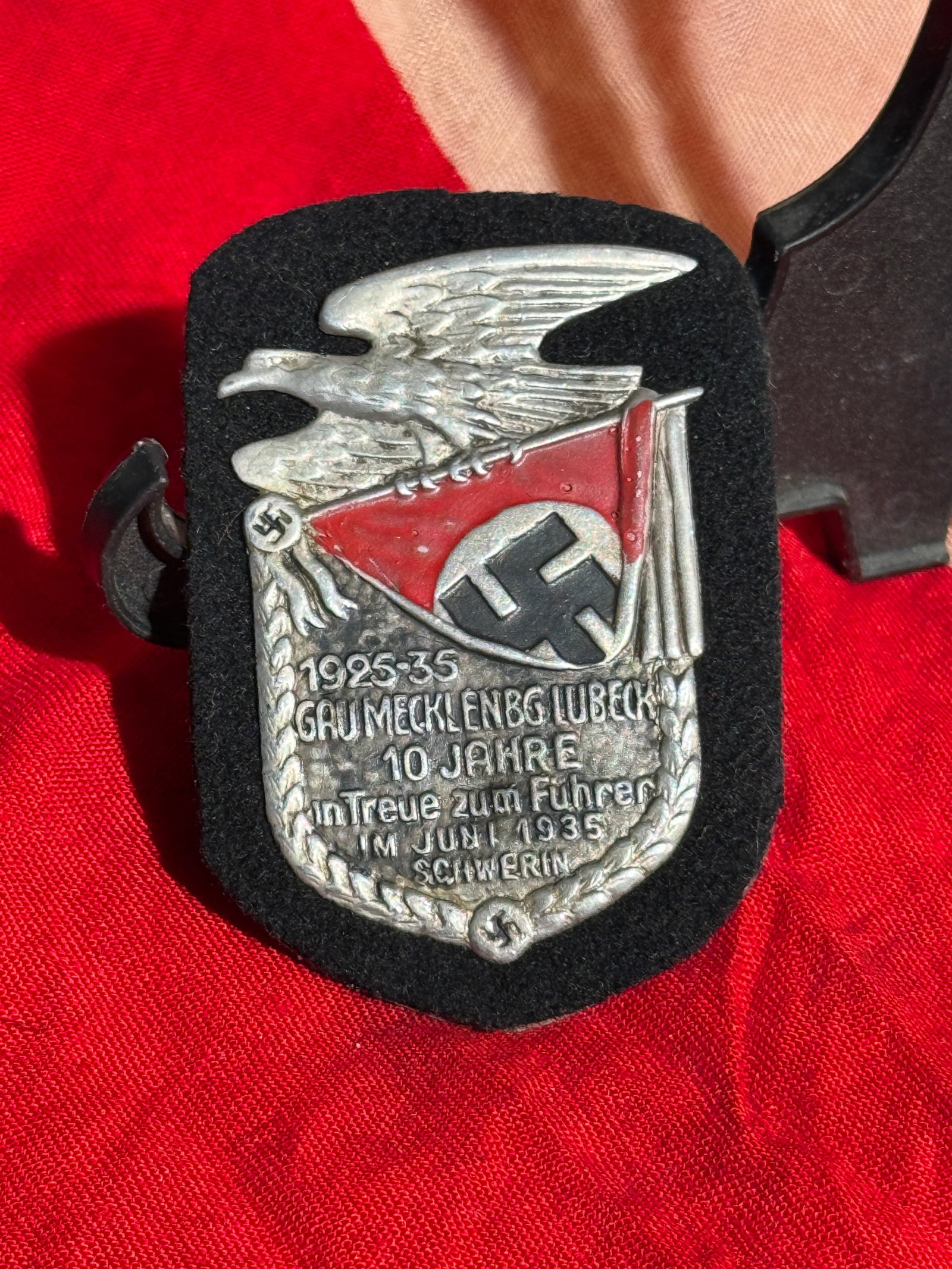 WW2 German NSDAP Gau Mecklenburg–Lübeck 10-Year Commemorative Badge, Schwerin, 1935 By RZM: Political commemorative badge issued by the Nazi Party (NSDAP) for the 10th anniversary of party activity in Gau Mecklenburg–Lübeck, marking the period 1925–1935. The badge features a national ea