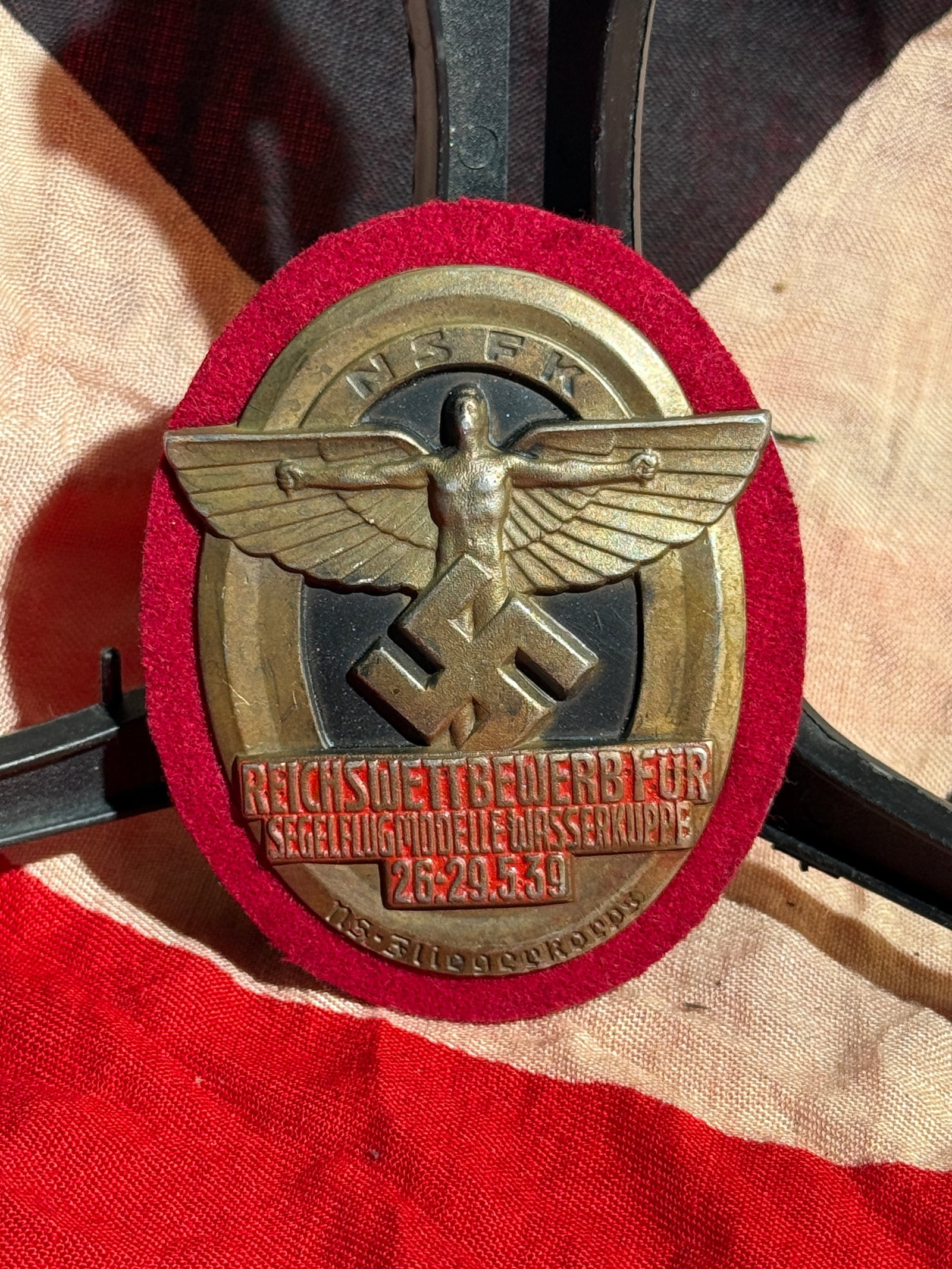 WW2 German NSFK Reich Competition Badge for Model Gliders, Wasserkuppe, 1939 By RZM: Oval metal badge issued for the National Socialist Flying Corps (NSFK) Reich Competition for Model Gliders, held at Wasserkuppe, Germany, 26–29 May 1939. The obverse features a stylized winged figur