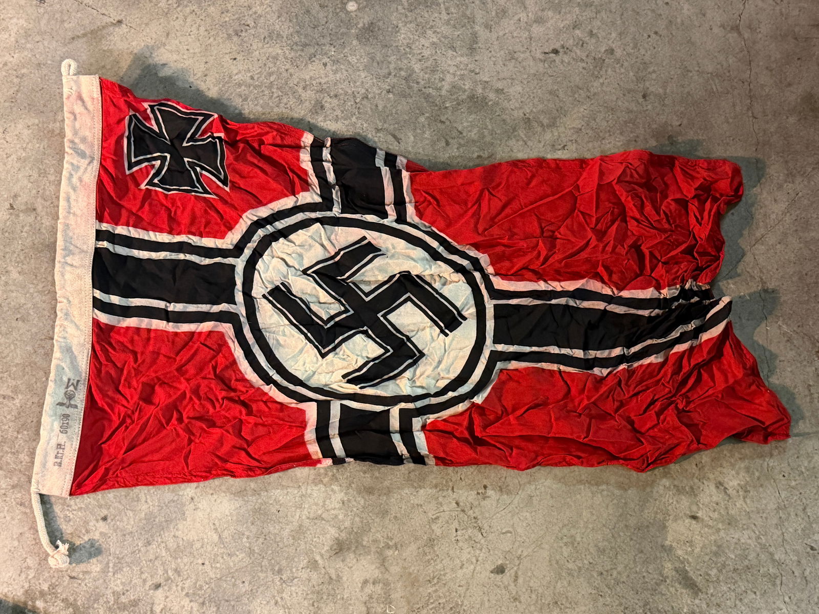 WW2 German Kriegsmarine Naval Ensign (War Flag), Nazi Germany, c. 1935–1945 - Maker Marked: This German naval war ensign (Reichskriegsflagge) was used by the Kriegsmarine, the navy of Nazi Germany, during the Second World War. The flag features a red field with a black Nordic cross outlined