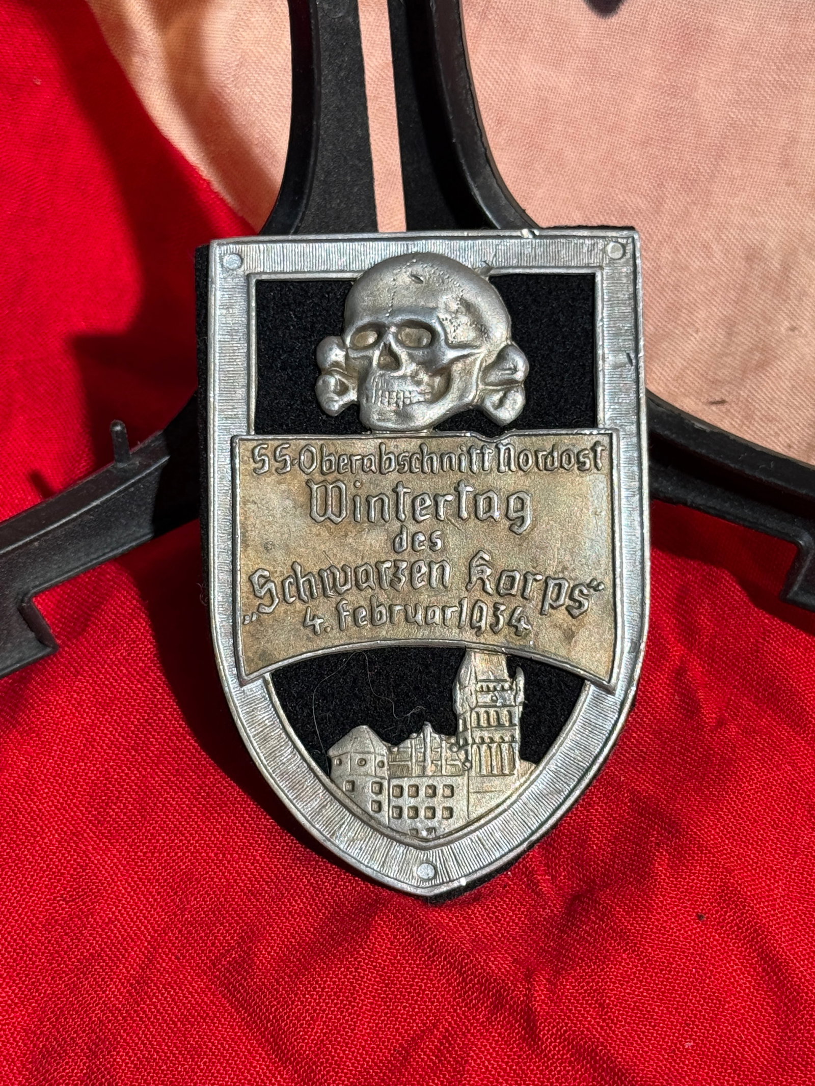 WW2 German 1934 SS Oberabschnitt Nordost Wintertag badge By Ges. Gesch.: SS “Wintertag des Schwarzen Korps” Shield Badge, 4 February 1934. Pressed metal commemorative badge featuring the SS Totenkopf above the inscription for the SS-Oberabschnitt Nordost Winter Day