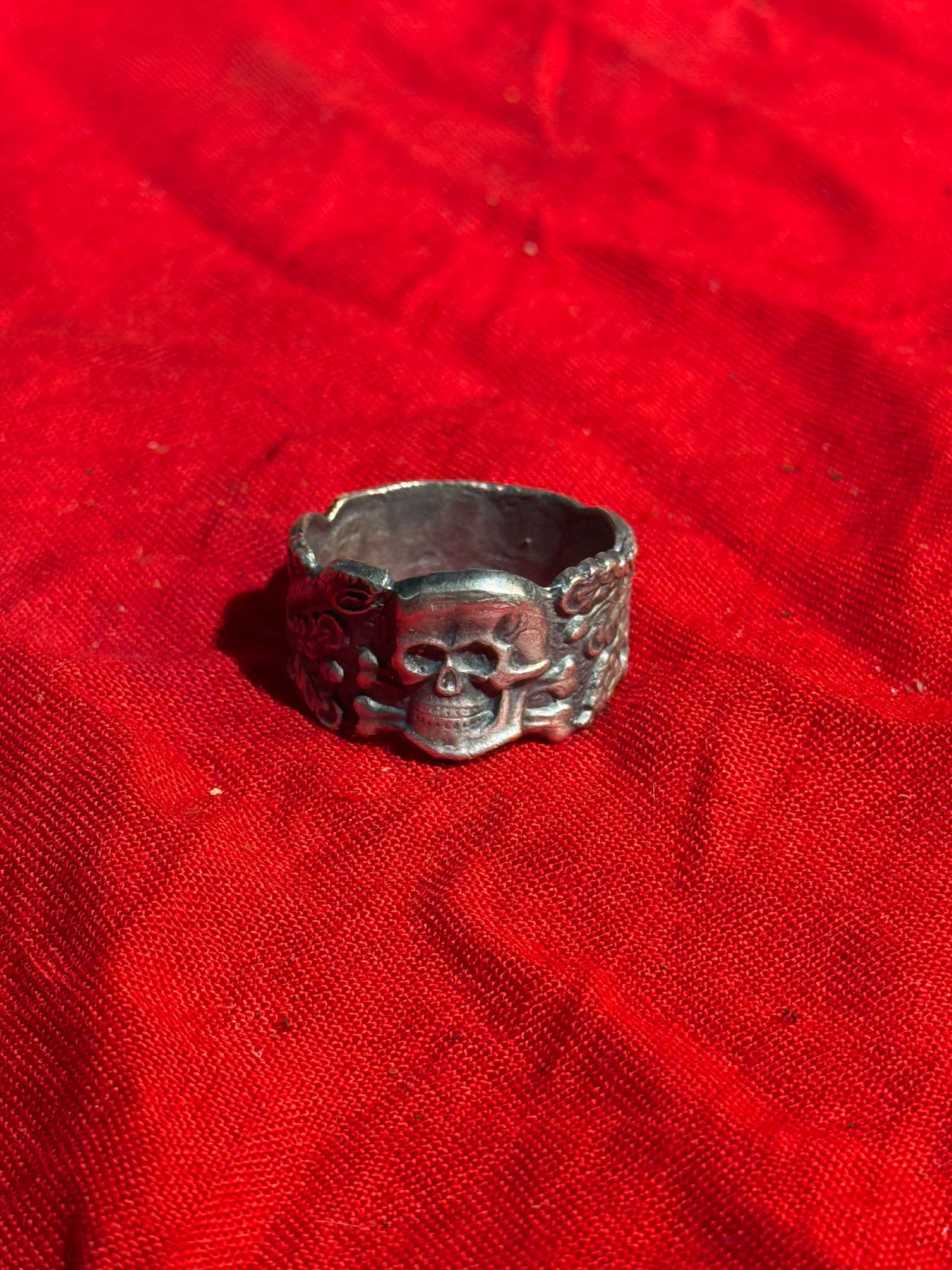 WW2 German Silver Skull and Oak Leaf Motif Ring in the Totenkopf Tradition: Silver ring featuring a raised skull and crossbones (Totenkopf) motif at the front, flanked by oak leaf and acorn decorations along the band. The skull symbol has a long history in European military c