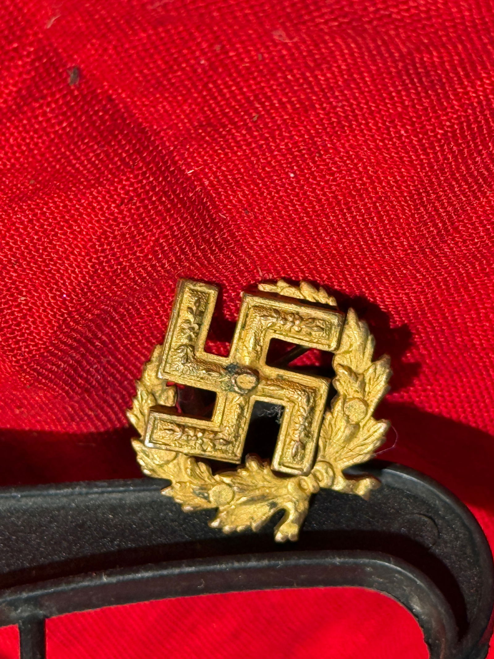 WW2 German National Socialist Party Membership Badge (Small Lapel Version): This small metal lapel badge displays a raised swastika (Hakenkreuz) centered within a decorative oak-leaf wreath, a traditional German symbol of strength and loyalty that was widely used in Nazi icon