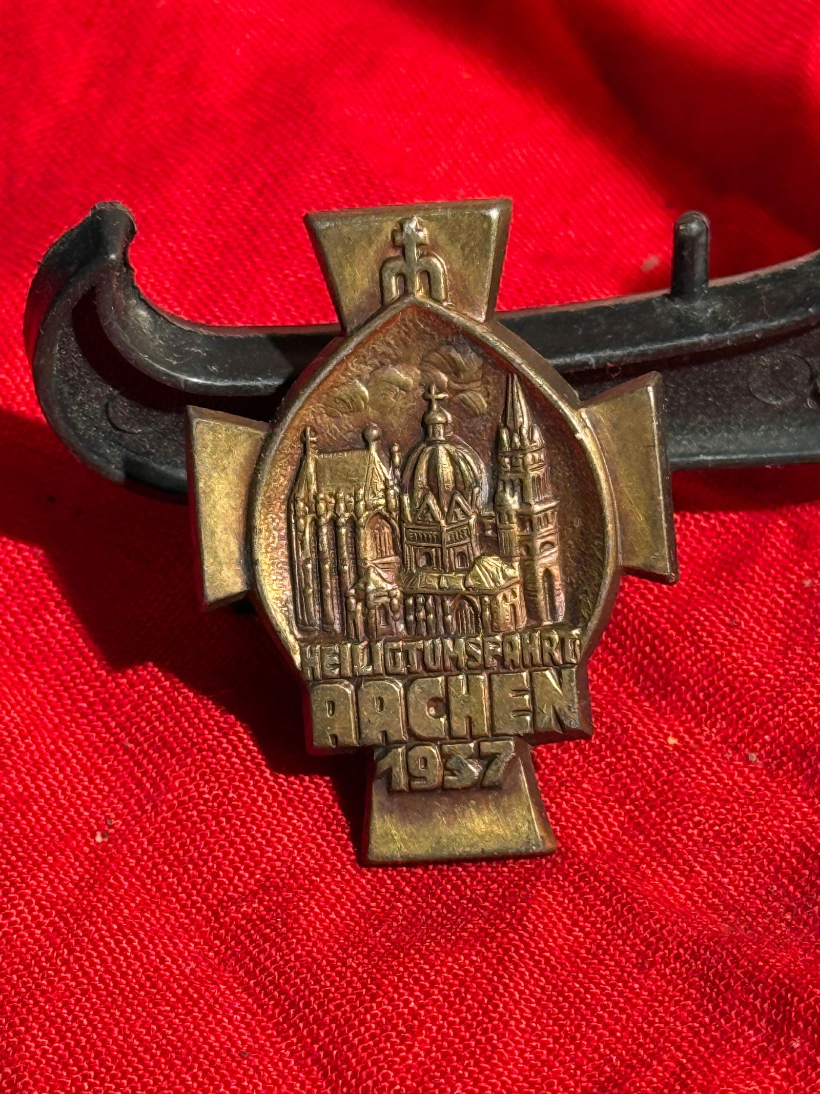 WW2 German Catholic Pilgrimage Badge – Aachen Pilgrimage (Heiligtumsfahrt), 1937: Bronze Catholic pilgrimage badge commemorating the Heiligtumsfahrt Aachen of 1937. The cross-shaped badge features a central oval relief depicting Aachen Cathedral, including the domed Palatine Chapel