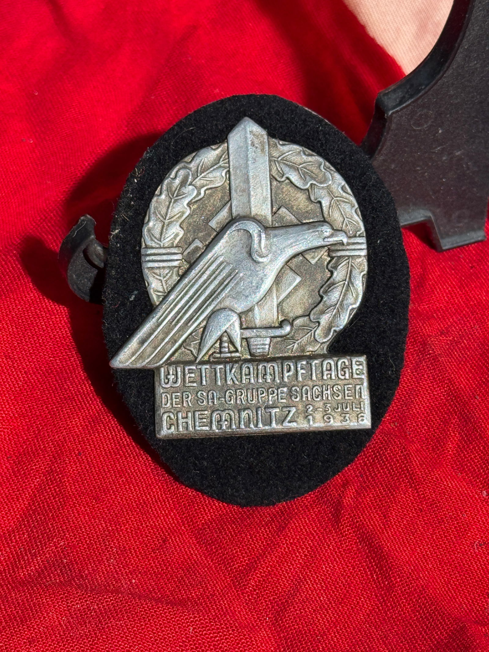 WW2 German SA Wettkampftage Badge – Chemnitz, 1938: This metal badge commemorates the SA (Sturmabteilung) Wettkampftage, or “competition days,” held in Chemnitz, Saxony, Germany, from July 2–3, 1938. The design features a stylized eagle in