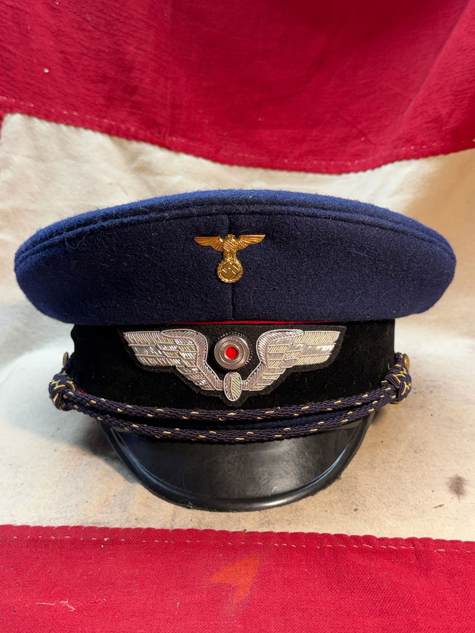 WW2 German Police Officer’s Peaked Cap (Polizei Schirmmütze): This peaked service cap (Schirmmütze) was worn by an officer of the German Ordnungspolizei (Order Police) during the Third Reich period. The cap is constructed of dark blue wool with a black velvet c