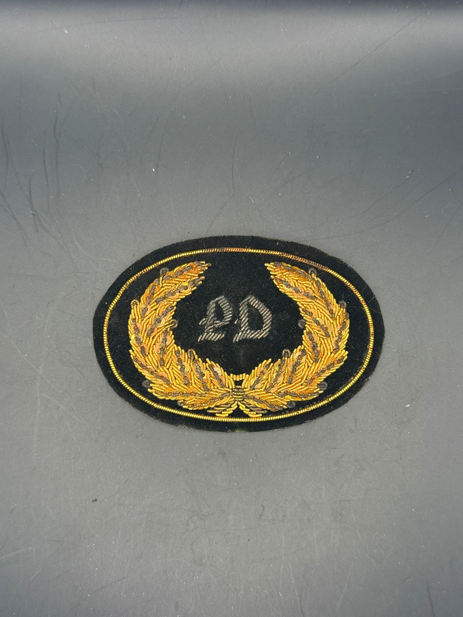 Rare Civil War PD Police Department Bullion Headgear Badge By John A. Baker: This hand-embroidered bullion insignia features the numeral “PD” surrounded by a gold laurel wreath on black velvet, identifying Police Department Division uniform device made for formal milit