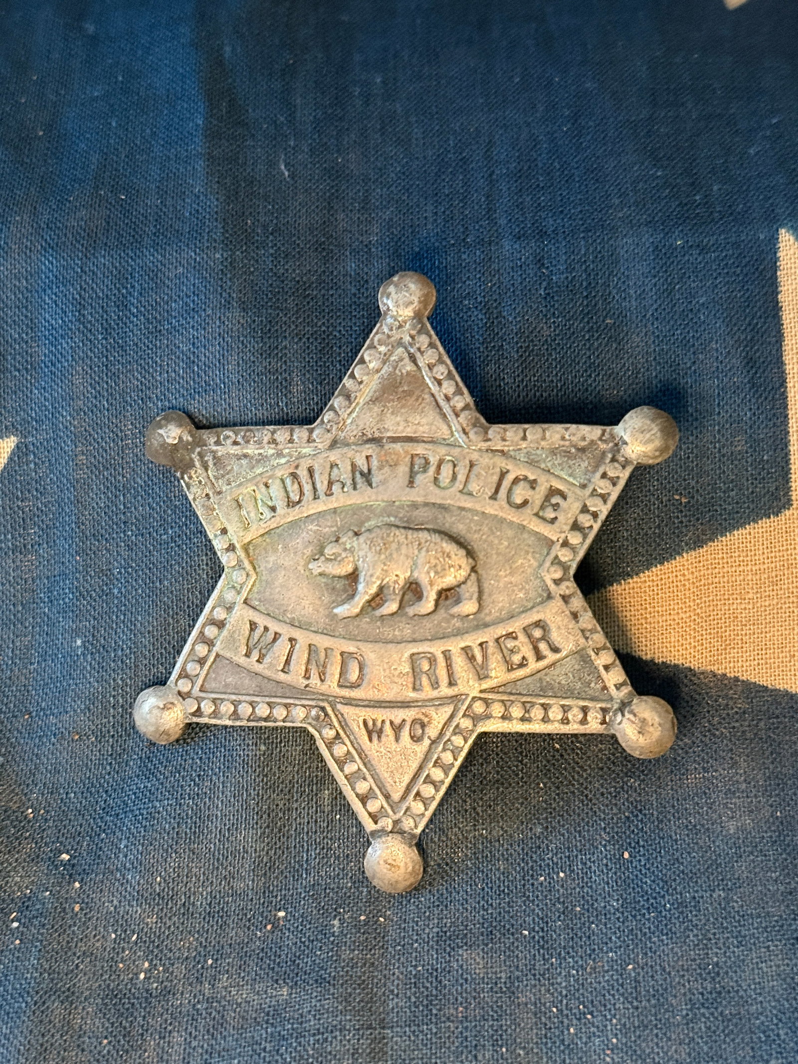 1800's Reservation Police Badge, “Indian Police – Wind River, Wyo.??, frontier commemorative: Cast metal six-point badge inscribed “INDIAN POLICE / WIND RIVER / WYO”, with central raised bear motif and dotted border decoration. The form imitates reservation police insignia associated w