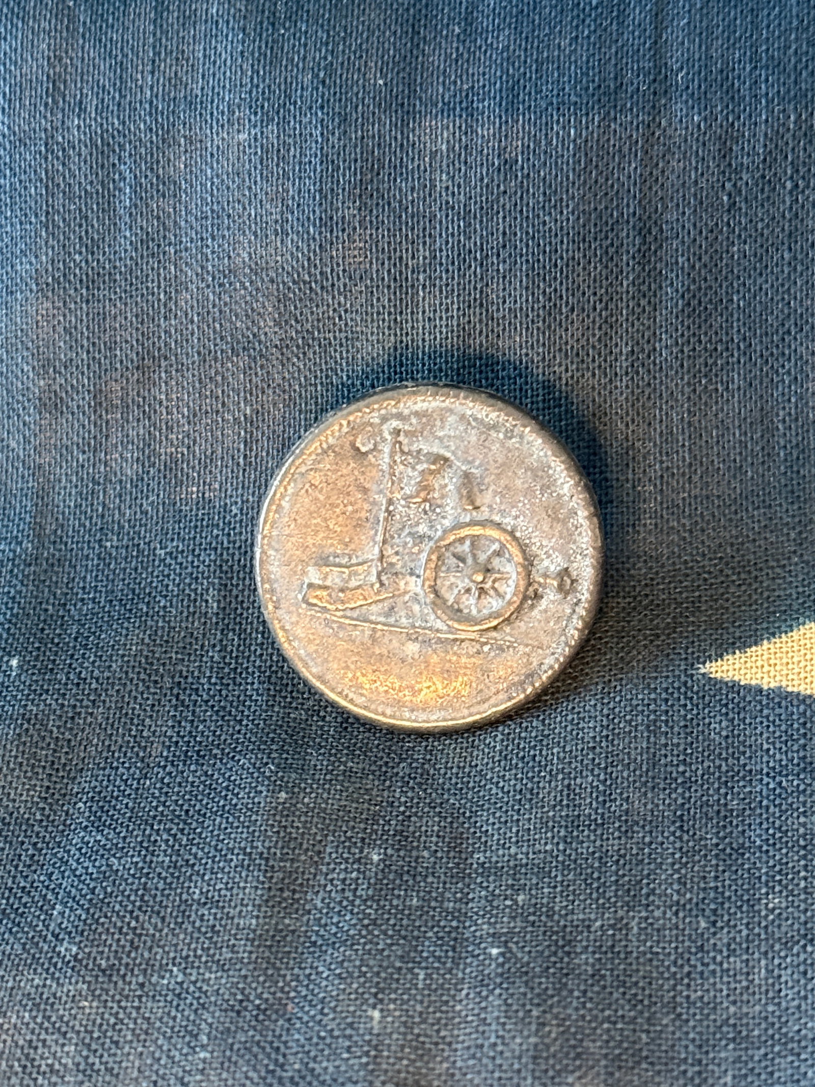Revolutionary War Continental Artillery Pewter Button, c. 1775–1783: American Revolutionary War Continental Artillery uniform button, cast in pewter and featuring a raised field cannon motif with spoked wheel and carriage. This simple yet distinctive design was used to