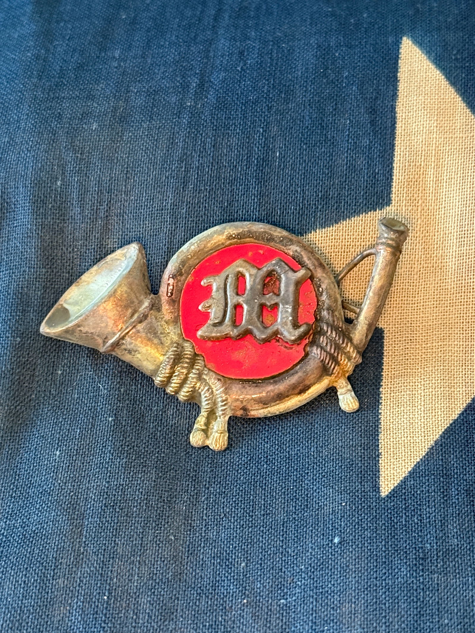 1859 regulation U.S Marine Corps enlisted man's hat insignia: Brass insignia in the form of a hunting horn (bugle), featuring the letters “USMC” placed within the circular loop of the horn. The device was worn on the front of the enlisted Marine’s hat