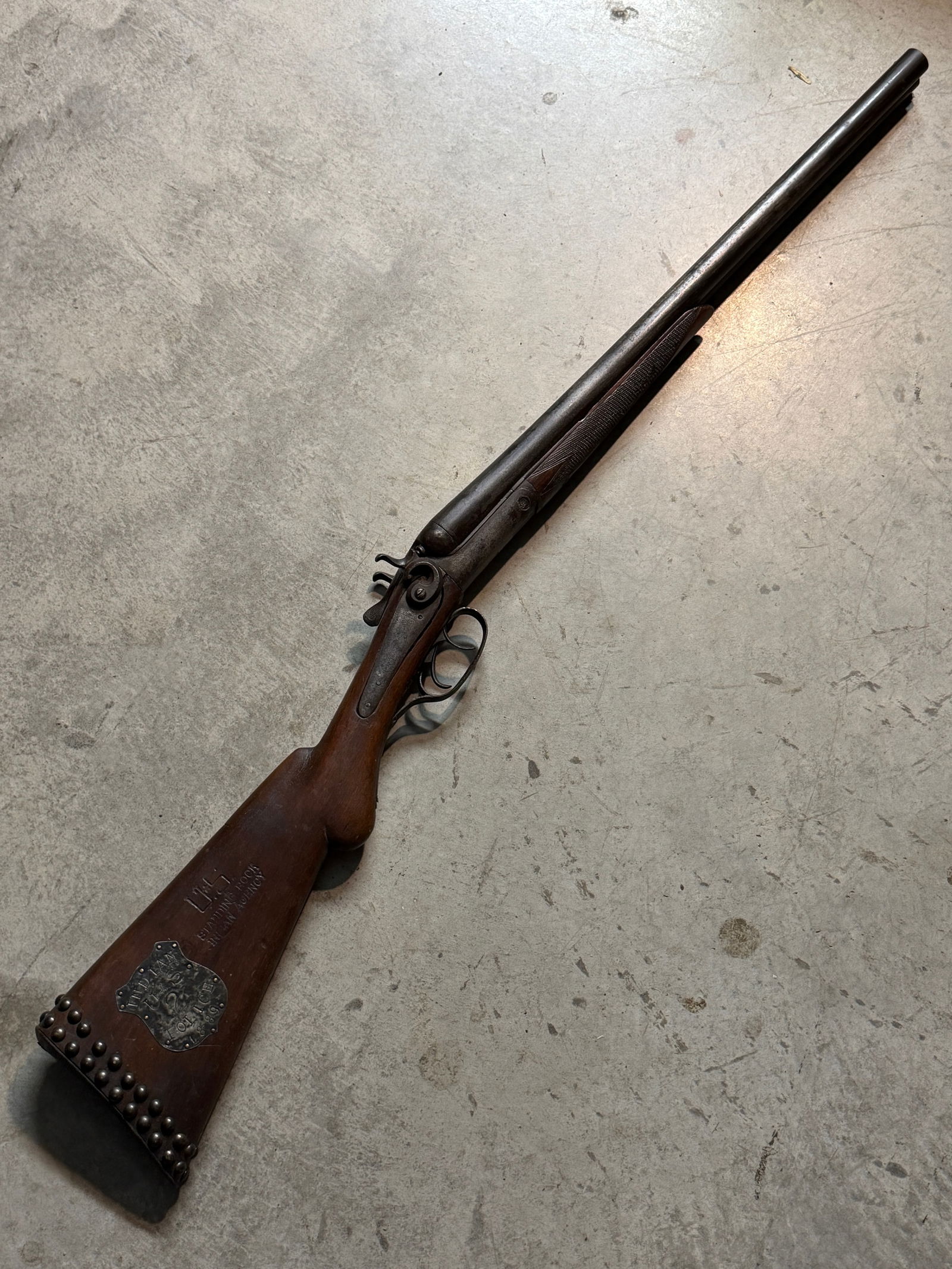1889 Double-Barrel Shotgun Attributed to U.S. Indian Police, Standing Rock Agency: This double-barrel, side-by-side shotgun is attributed to service within the U.S. Indian Police at the Standing Rock Agency in the late 19th century. The wooden stock bears multiple period-style marki