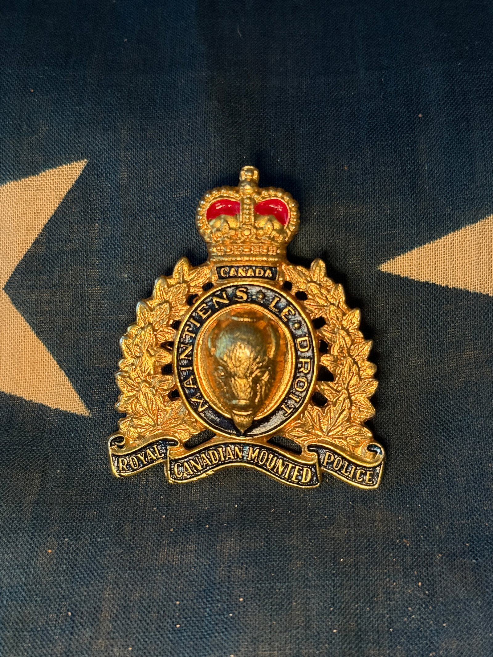 Royal Canadian Mounted Police (RCMP) Cap Badge: This badge is an insignia associated with the Royal Canadian Mounted Police (RCMP), Canada’s national police service. The design features a buffalo (bison) head at the center, surrounded by a circul