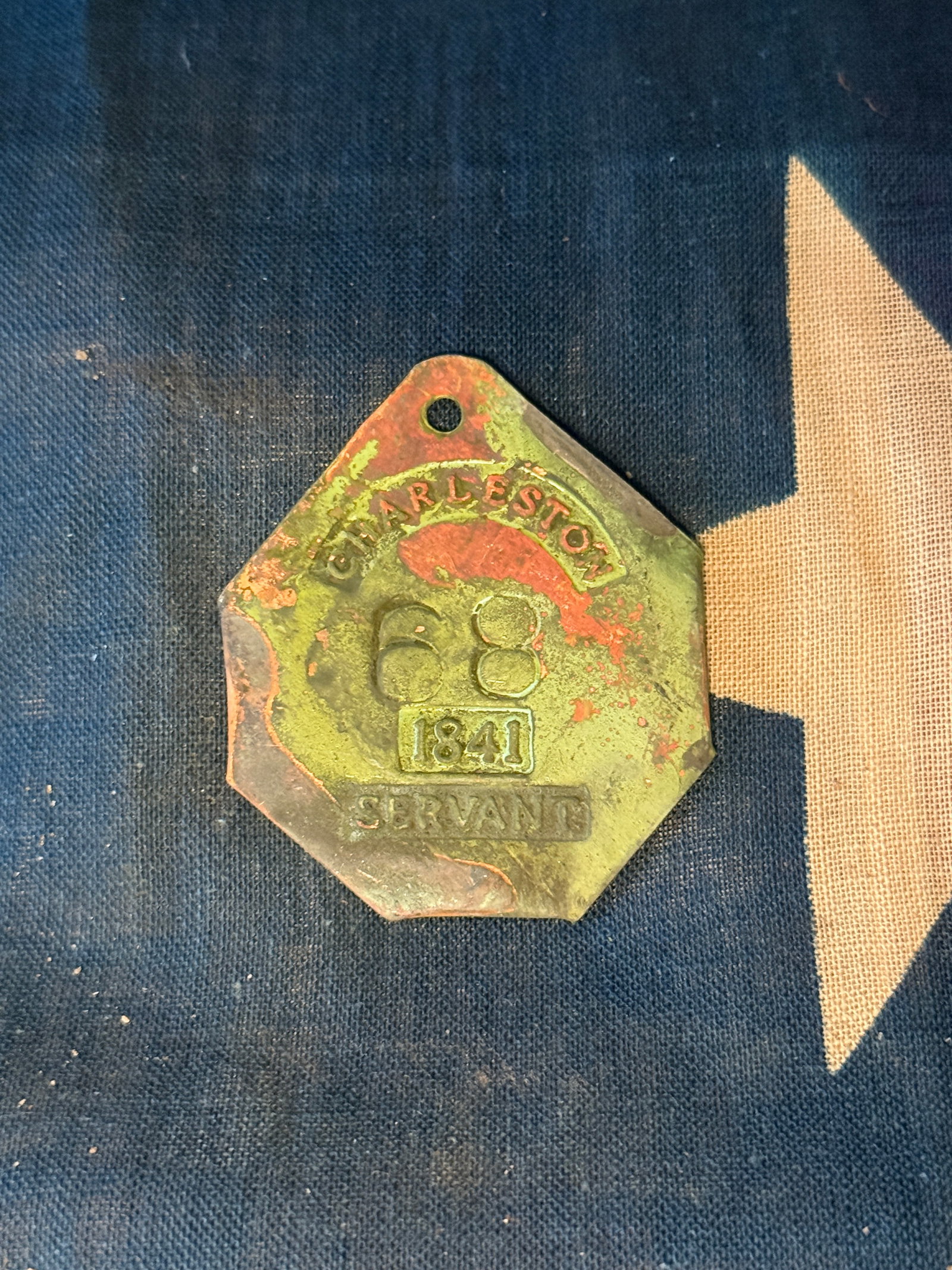 1841 Servant Identification Badge, Charleston, South Carolina Slave Tag: This brass identification badge is stamped “CHARLESTON / 68 / 1841 / SERVANT.” It was issued by the city of Charleston, South Carolina, as part of a municipal licensing system that regulated e
