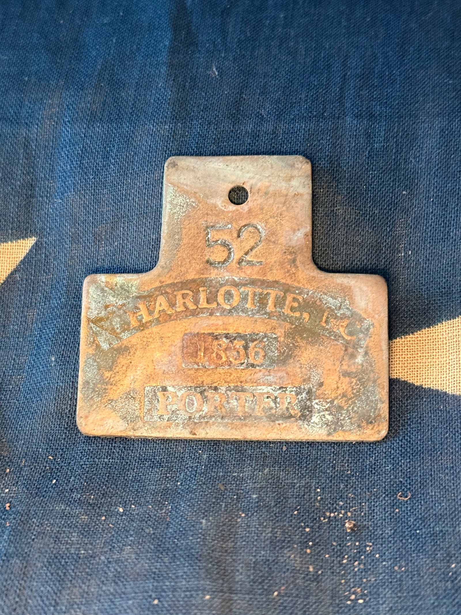 1856 Municipal Labor Badge for a Porter, Charlotte, North Carolina Slave Tag: This stamped metal badge reads “CHARLOTTE, N.C. / 52 / 1856 / PORTER.” It was issued by the city of Charlotte as part of a municipal licensing system regulating certain types of laborers in th