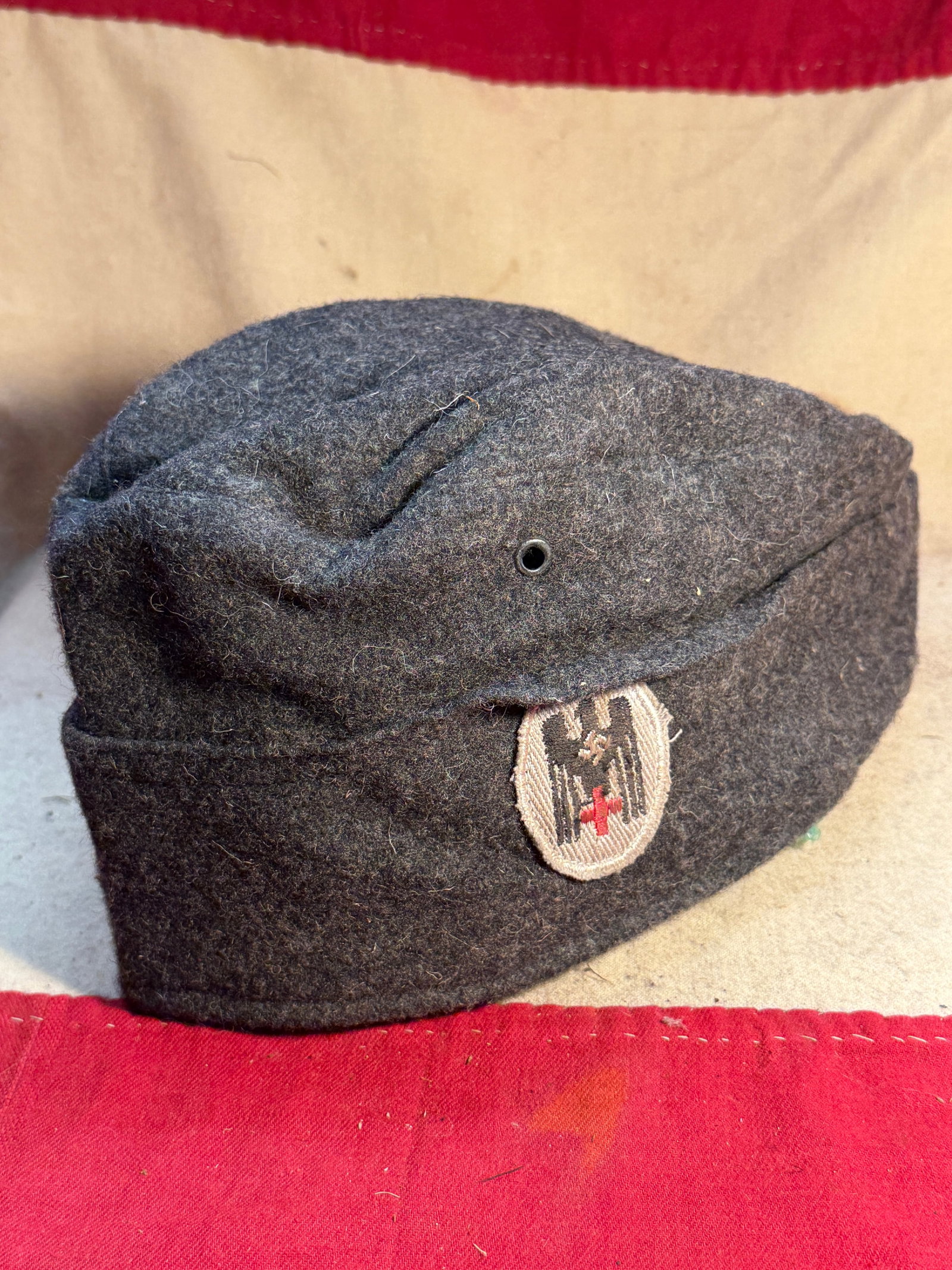 WW2 German Red Cross (Deutsches Rotes Kreuz) Field Side Cap, Germany, c. 1939–1945: This wool field side cap is attributed to the German Red Cross (Deutsches Rotes Kreuz, DRK), an organization that operated alongside German military forces during the Second World War, providing medic