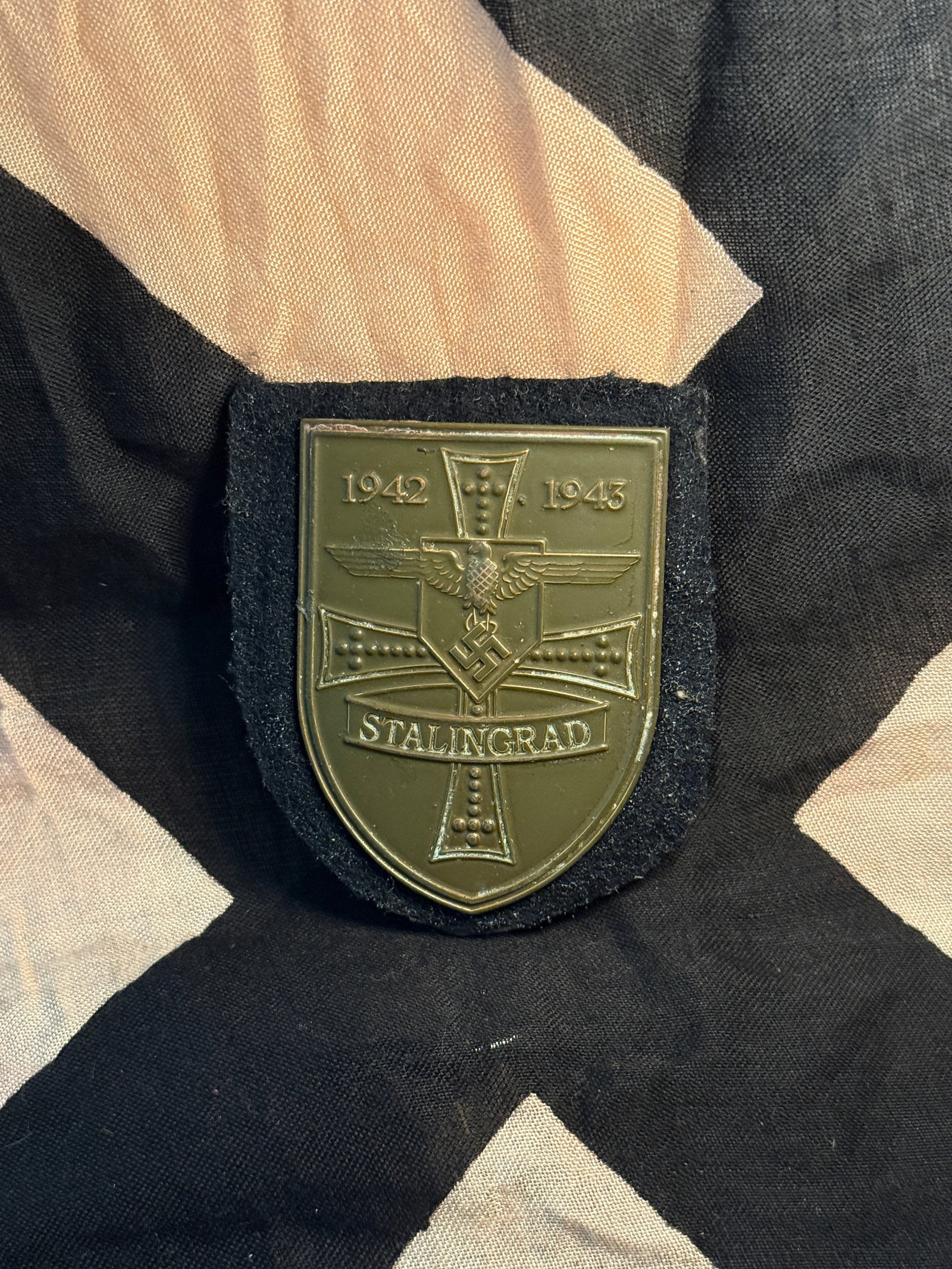 WW2 German “Stalingrad 1942–1943?? Commemorative Shield Plaque: This shield-shaped plaque commemorates the Battle of Stalingrad (1942–1943), one of the most significant and devastating battles of the Second World War. The front displays a stylized Iron Cross mot