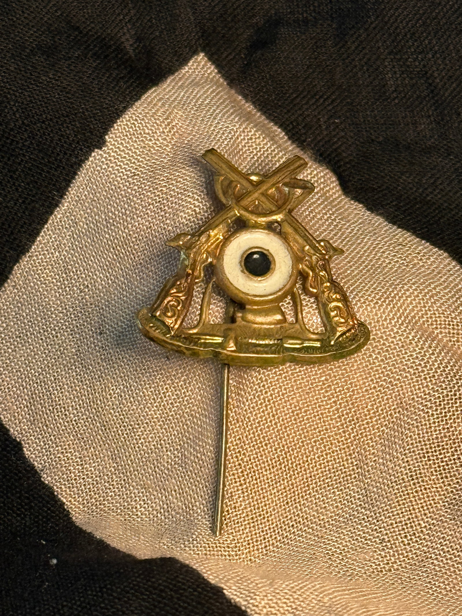 WW2 German Military-Themed Stick Pin with Crossed Rifles: This small lapel stick pin depicts crossed rifles above a stylized military emblem, a motif commonly associated with infantry or marksmanship traditions in Germany. Stick pins of this type were popula