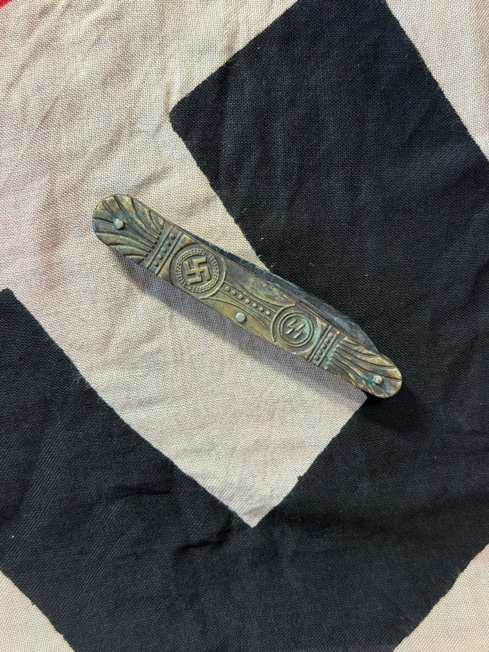 WW2 GERMAN Folding Pocket Knife with SS and Political Emblems: This multi-blade folding pocket knife features decorative grips incorporating SS runes and political-era symbols, including a swastika motif. Such knives were often privately purchased items or souven