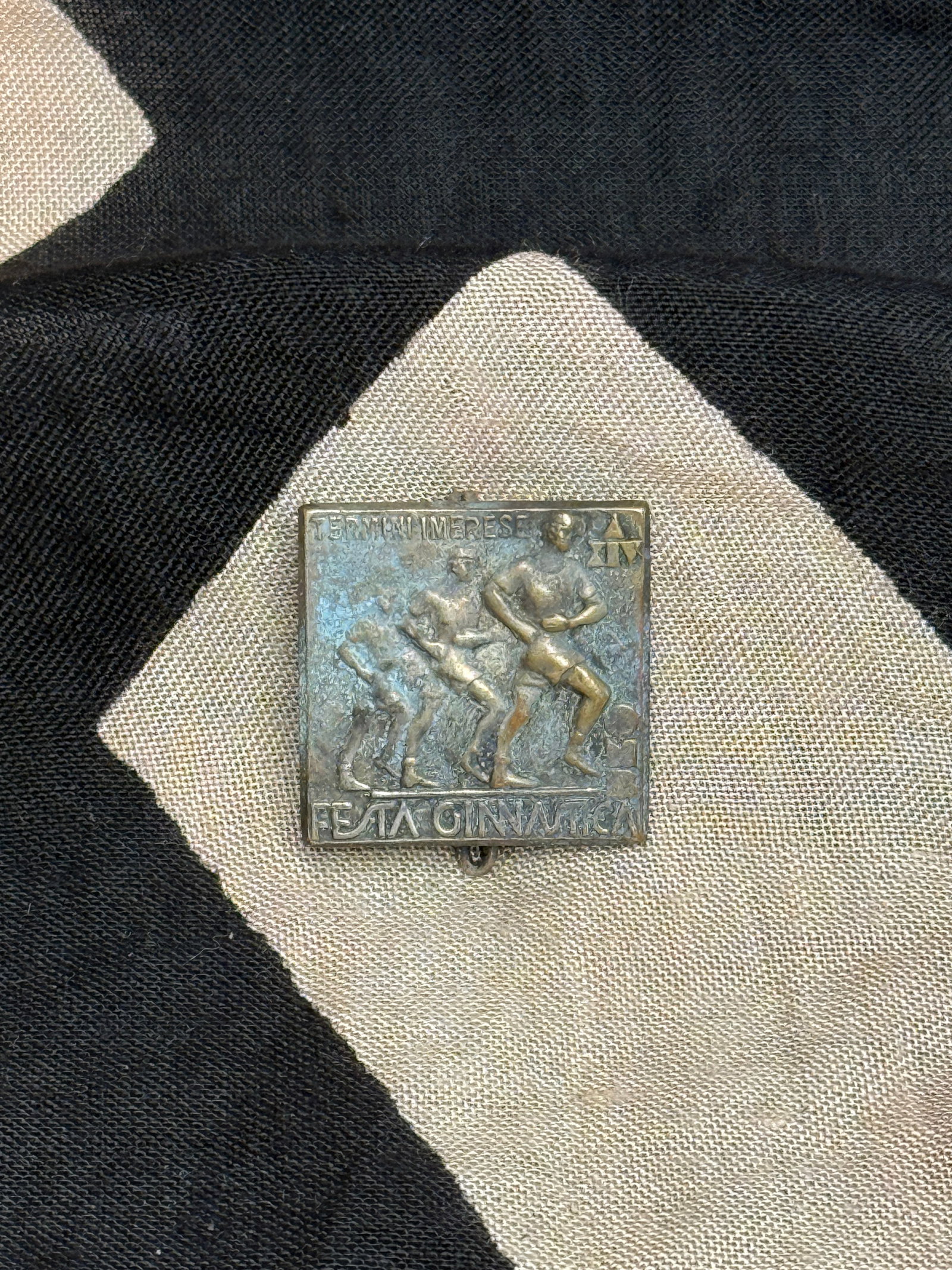 Italian Fascist Youth Gymnastics Badge (“Festa Ginnastica??): This bronze-toned badge depicts three stylized athletic figures in motion beneath the inscription “Festa Ginnastica” (“Gymnastics Festival”), with “Termini Imerese” at the top,