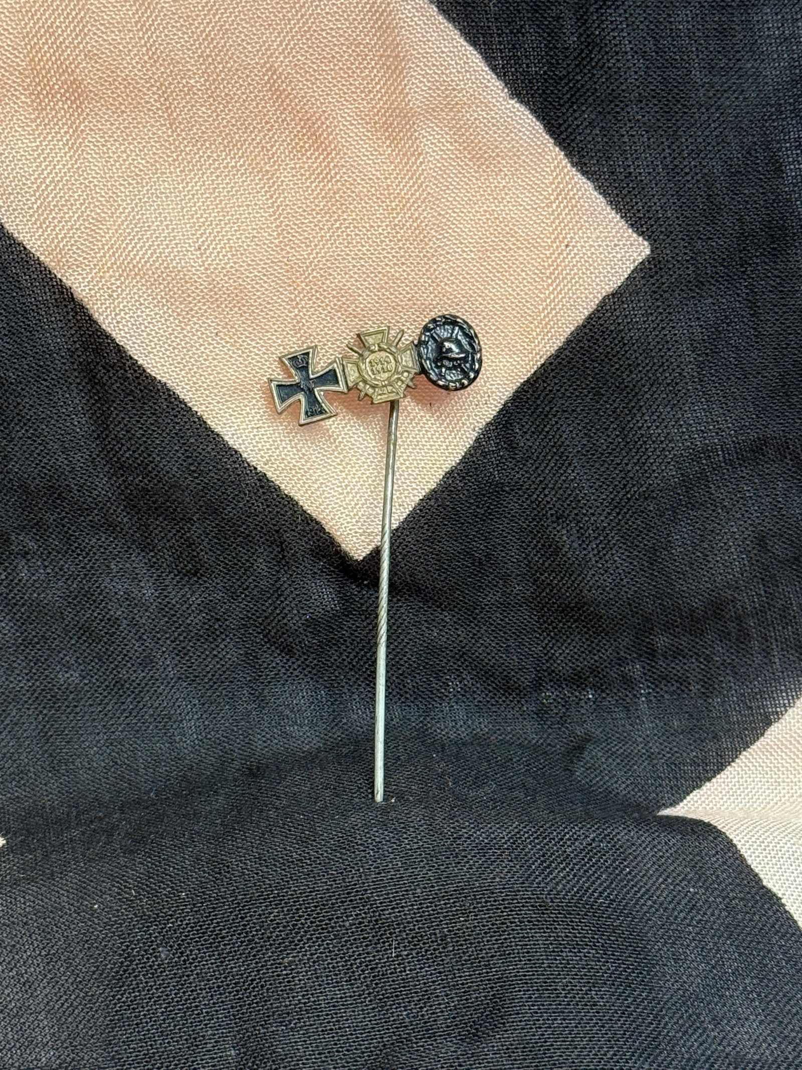 German World War I Commemorative Stick Pin with Iron Cross Motif: This miniature stick pin combines several symbols associated with German service in the First World War, including an Iron Cross, a central medallion marked “1914–1918,” and a small helmet e