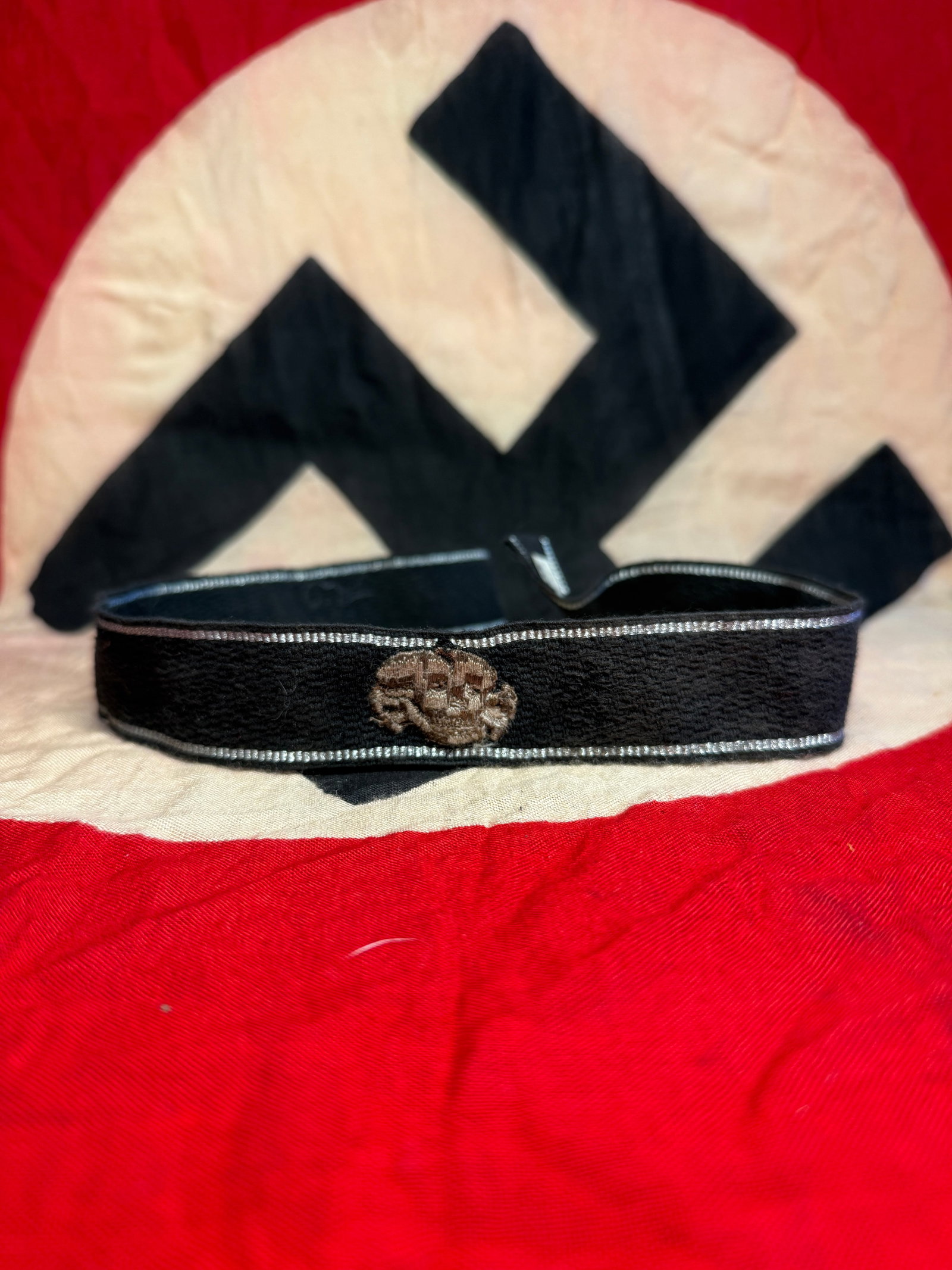 WW2 German Waffen-SS Totenkopf Insignia Cuff Title With RZM Paper Tag: This embroidered skull (Totenkopf) insignia represents one of the most recognizable symbols associated with the Waffen-SS. Such devices were worn on various uniform elements, including caps and sleeve