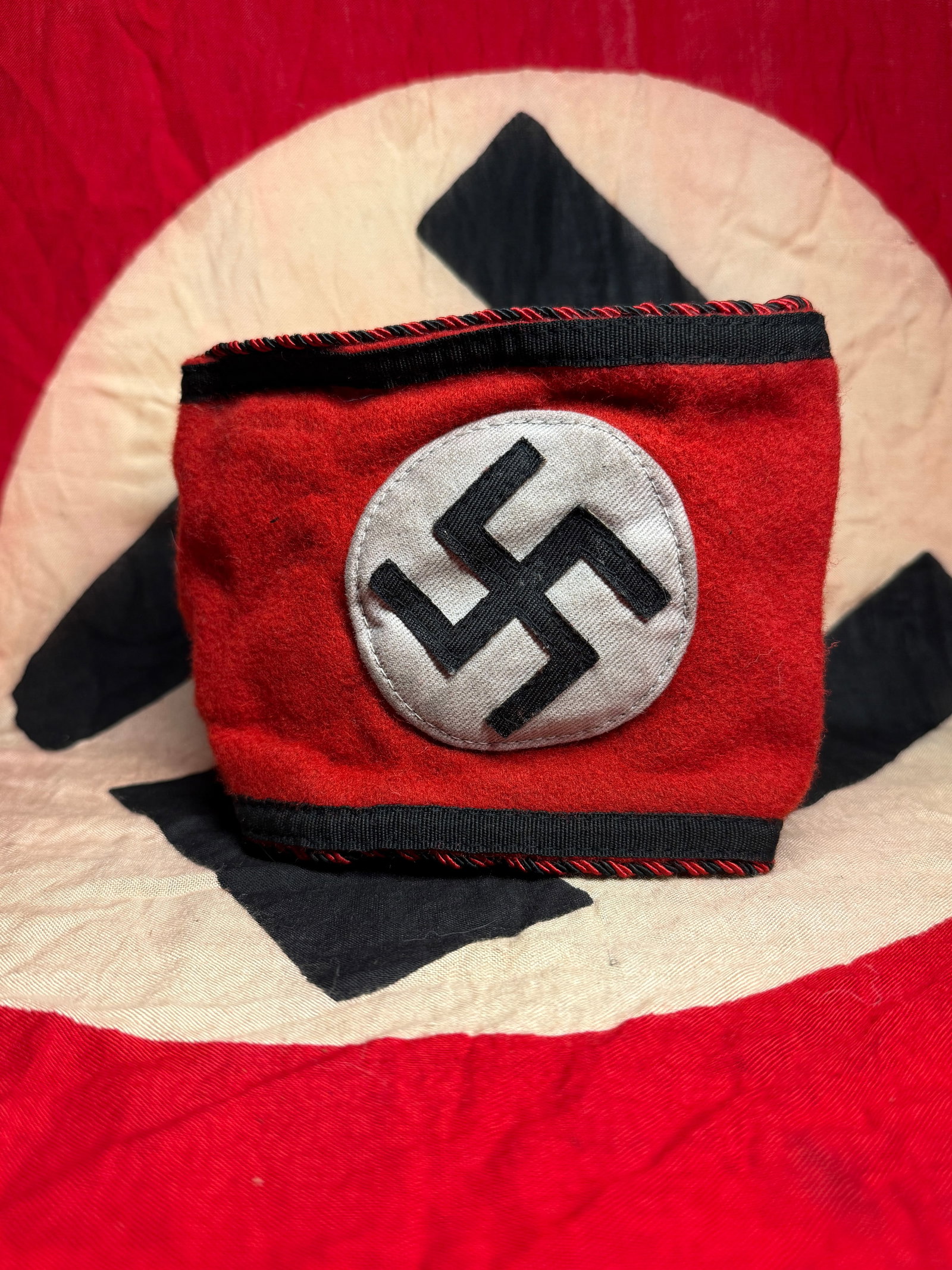 WW2 NSDAP Armband (Partei-Bereitschaft) With RZM Paper Tag: This red cotton armband bears the black swastika within a white roundel, accompanied by the printed text “NSDAP” and “Partei-Bereitschaft” (Party Readiness). Worn on the upper arm, suc