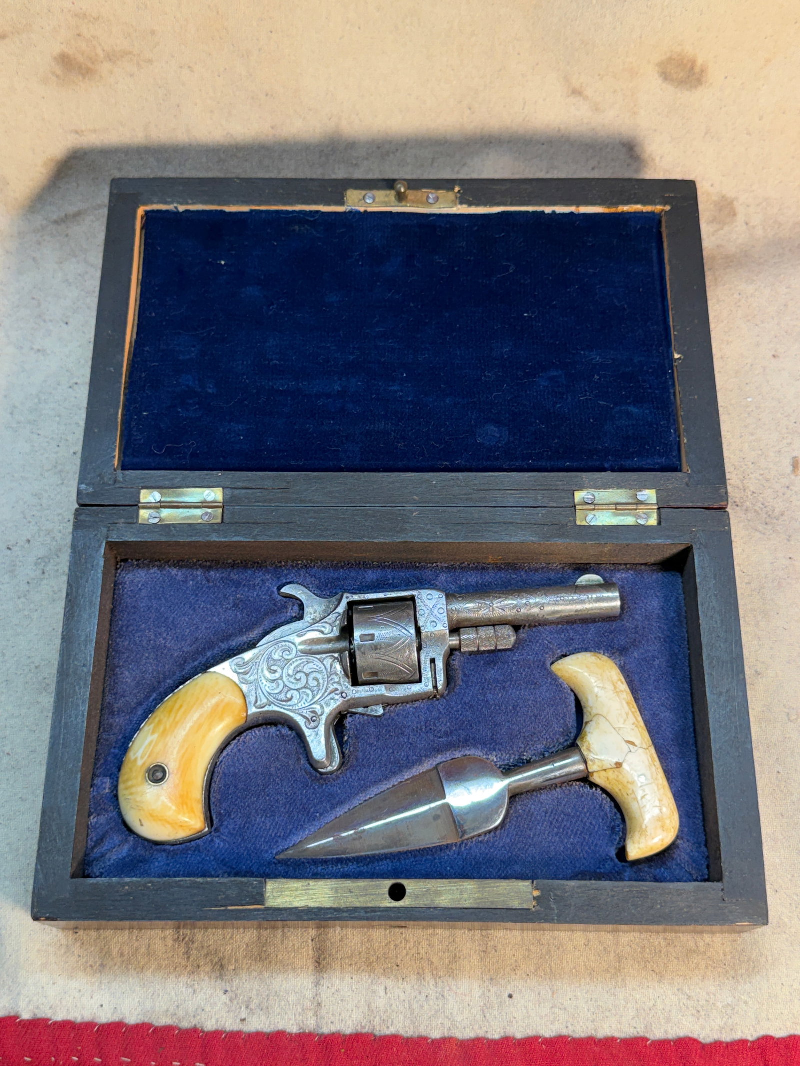 1800's Cased Engraved Pocket Revolver with Push Dagger, Attributed to M. Price, San Francisco: This late 19th-century cased set features an engraved pocket revolver paired with a push dagger, both arranged within a fitted wooden case lined in deep blue velvet. Compact, concealable, and purpose-