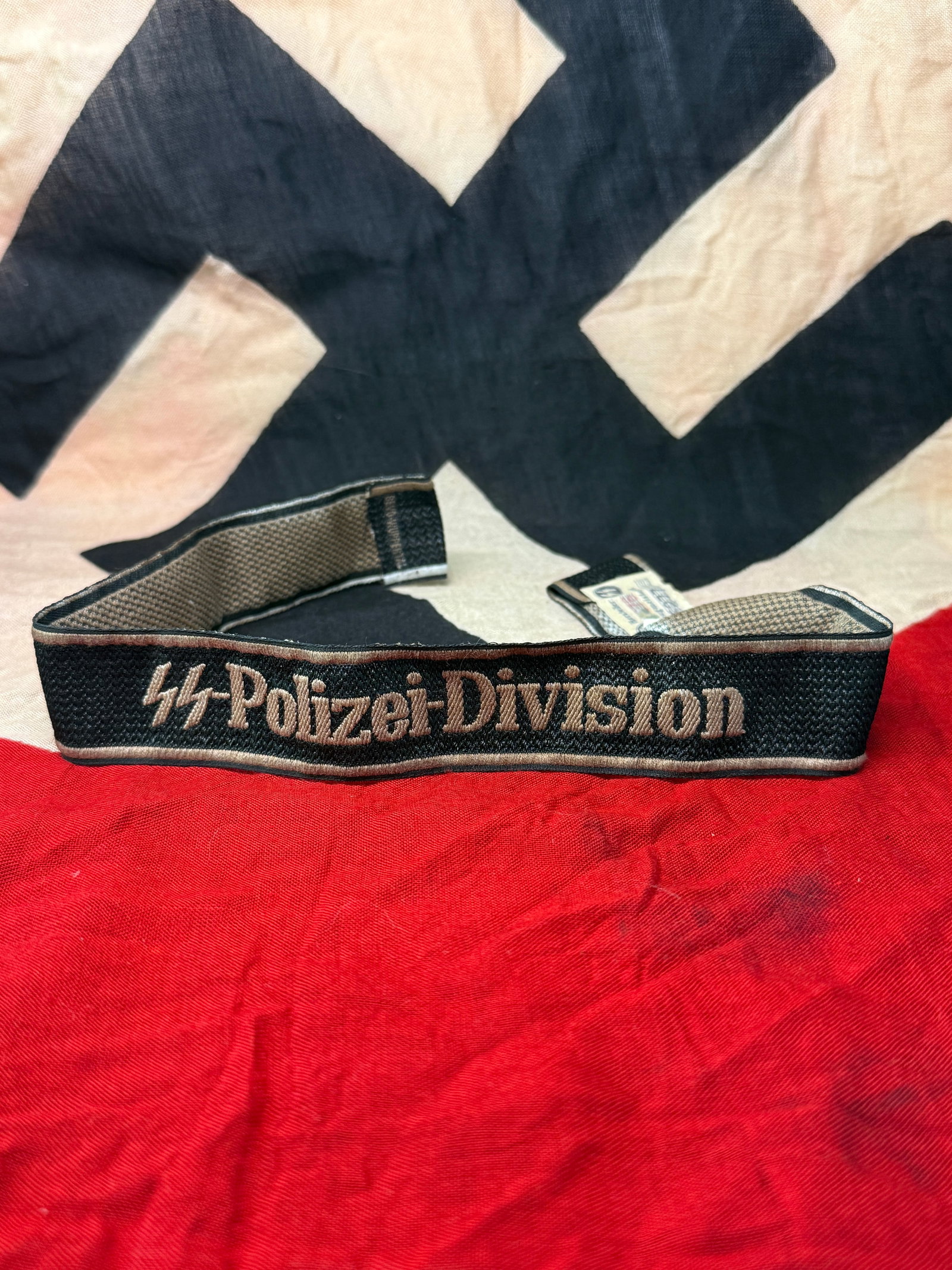 German WWII SS-Polizei-Division Cuff Title (4th SS Polizei Division), c. 1939–1945 With RZM Paper: This woven cuff title reads “SS-Polizei-Division,” denoting affiliation with a Waffen-SS formation originally composed of Ordnungspolizei (Order Police) personnel. The unit, later known as the